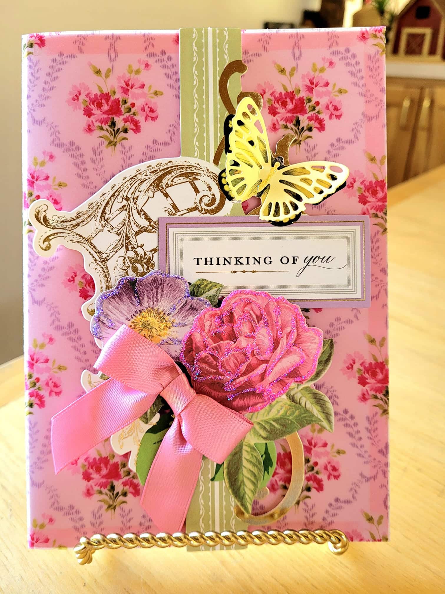 a card with a pink flower and a butterfly on it.