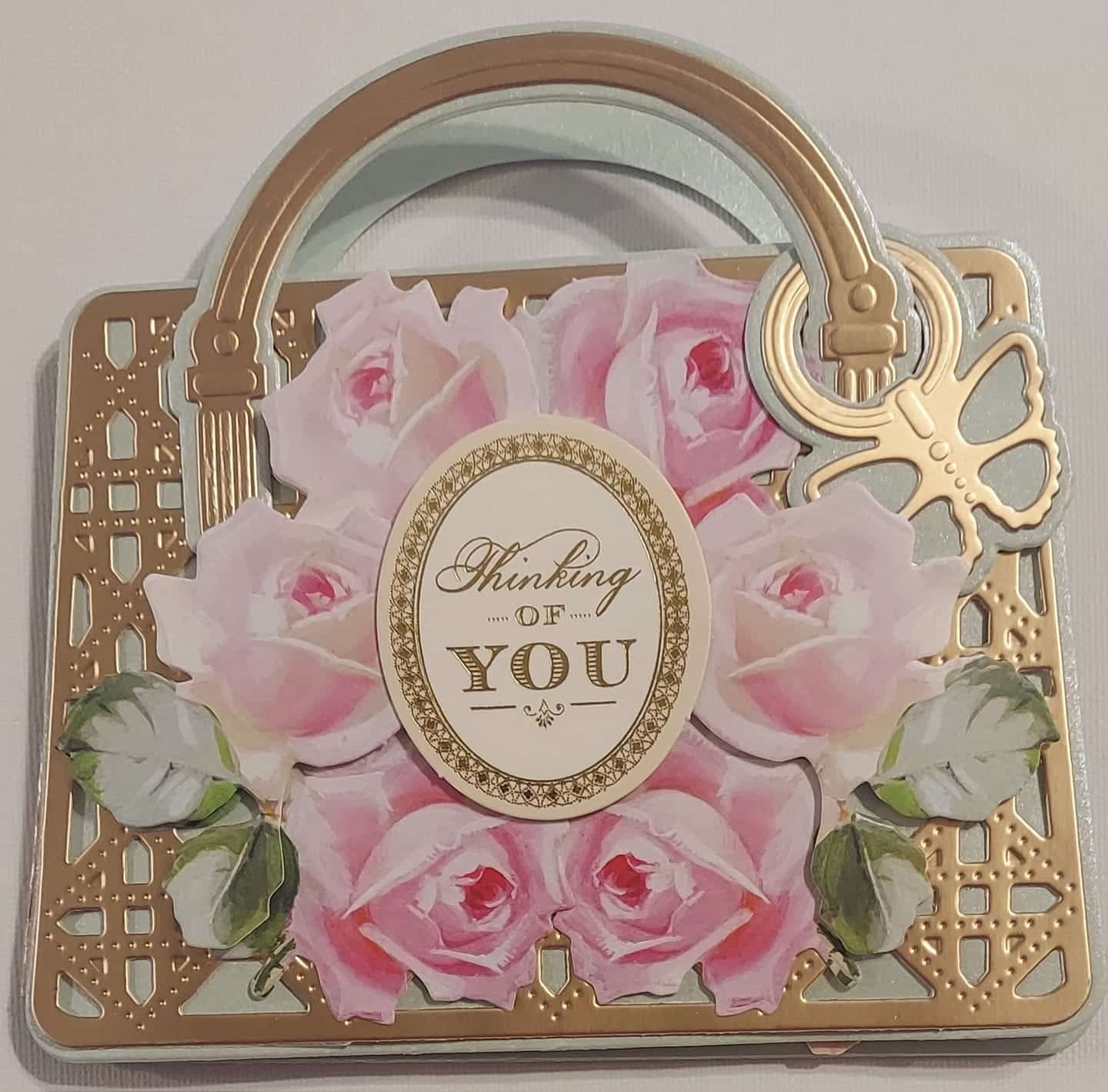 a card with pink roses and a cross on it.