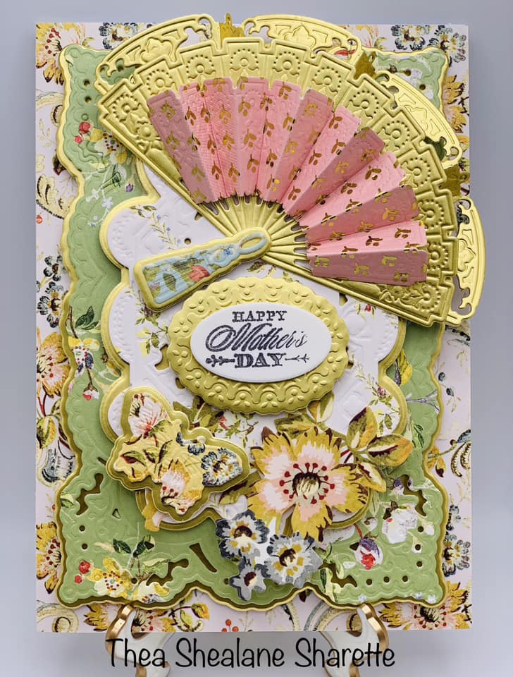 a card with a fan and flowers on it.