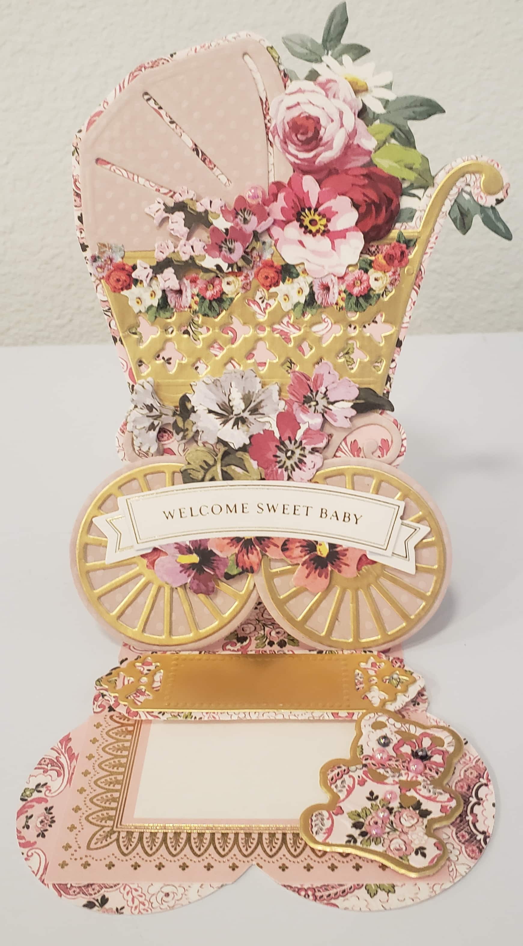 a card with a baby carriage and flowers on it.