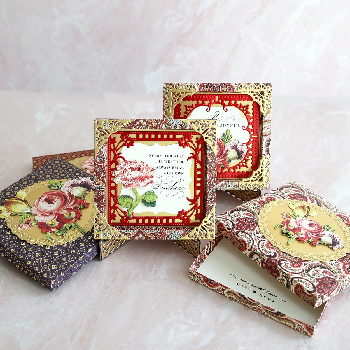 a set of four decorative boxes on a table.