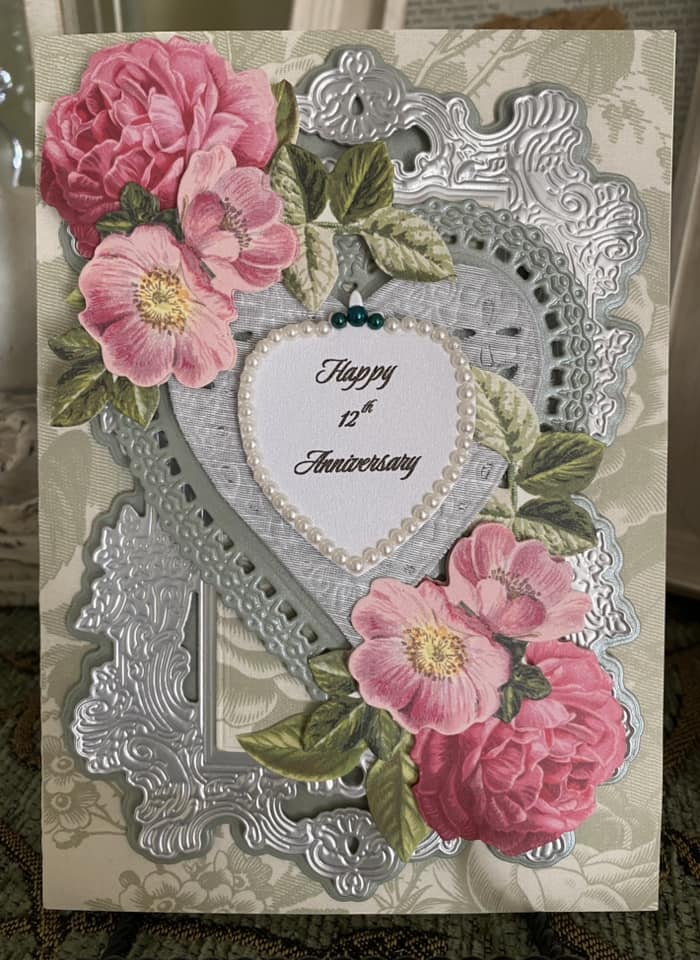 a card with a heart and flowers on it.