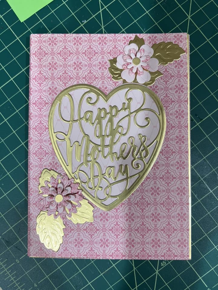 a card with a heart and flowers on it.