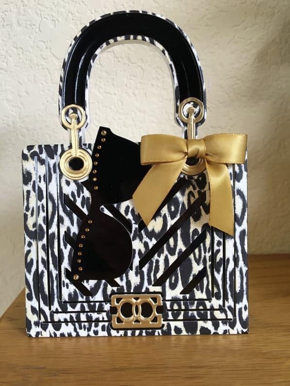 a white and black purse with a gold bow.