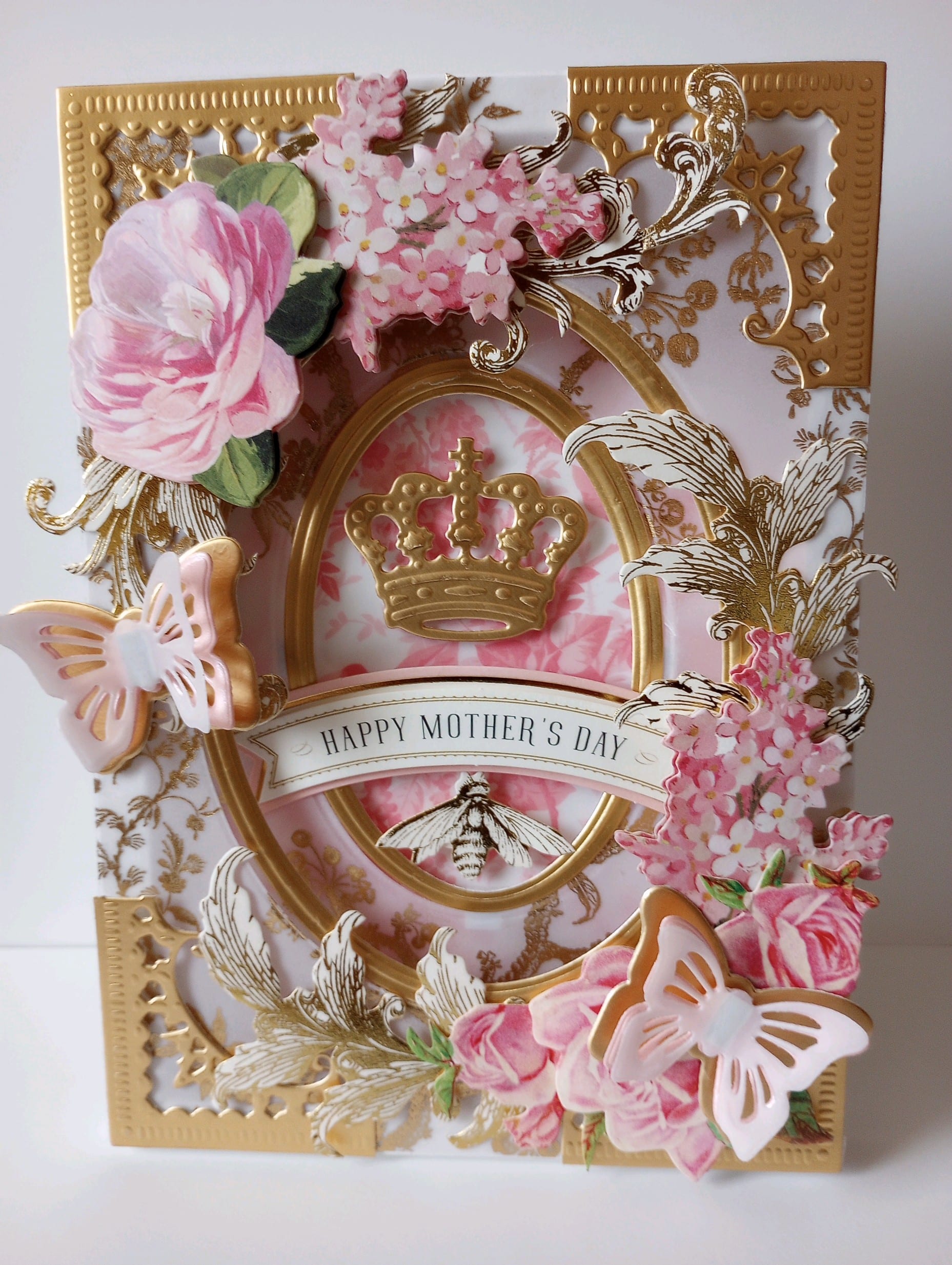 a mothers day card with flowers and a crown.