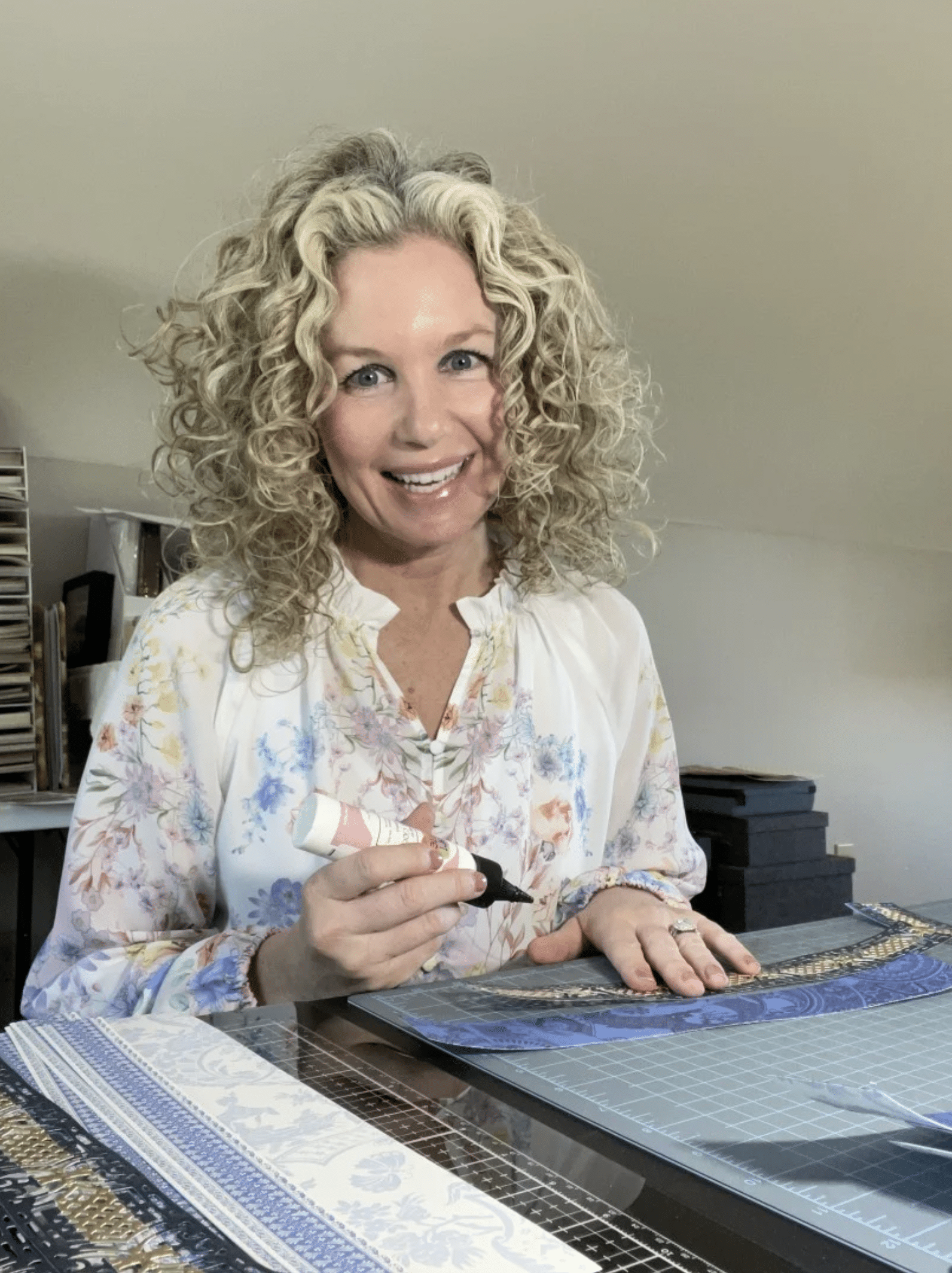 a woman sitting at a table with a large piece of paper.