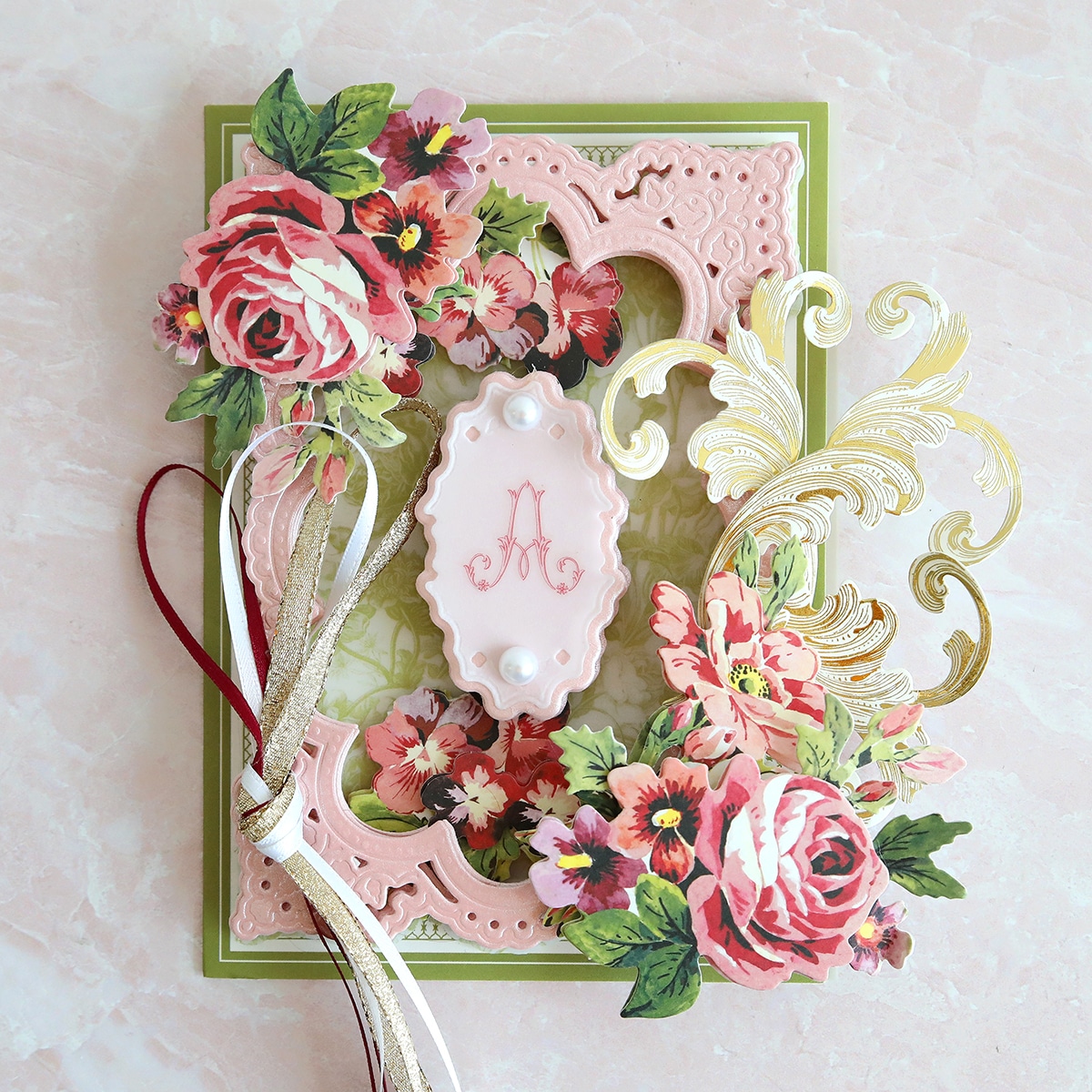 a pink card with flowers and a ribbon.