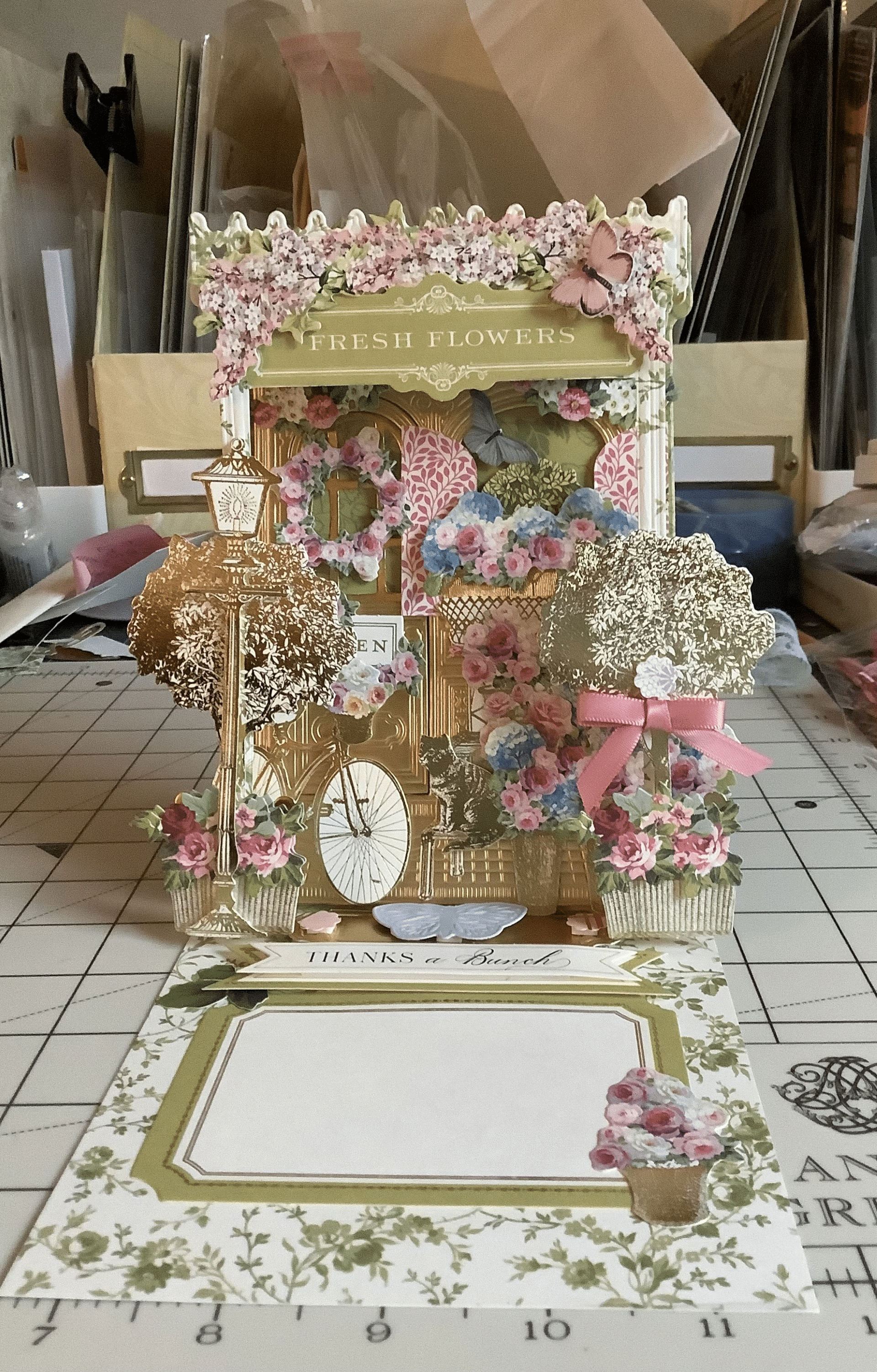 a table topped with a clock and flowers.