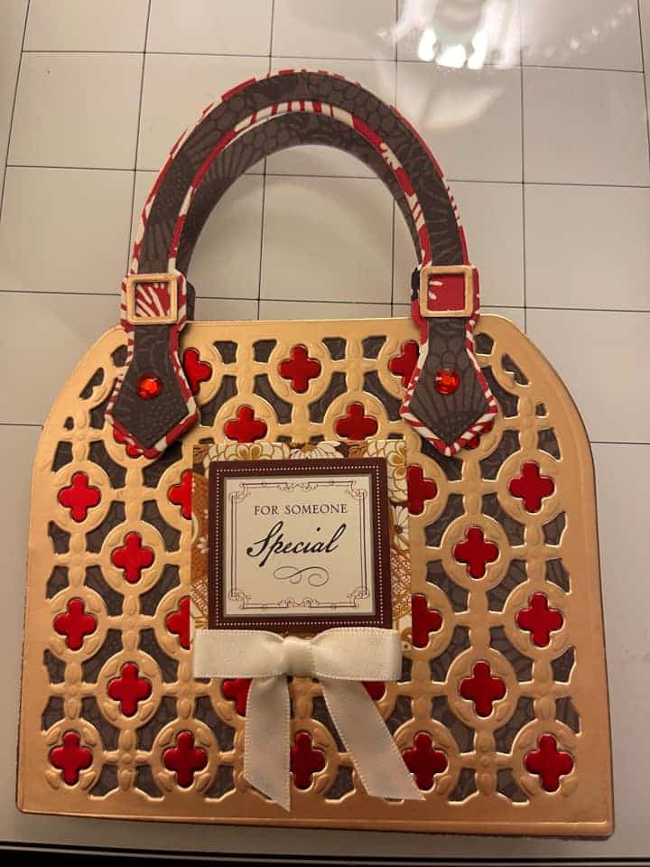 a handbag with a red bow on top.