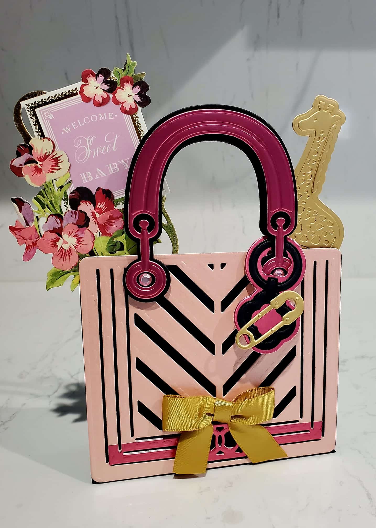 a pink and black purse with a yellow bow.