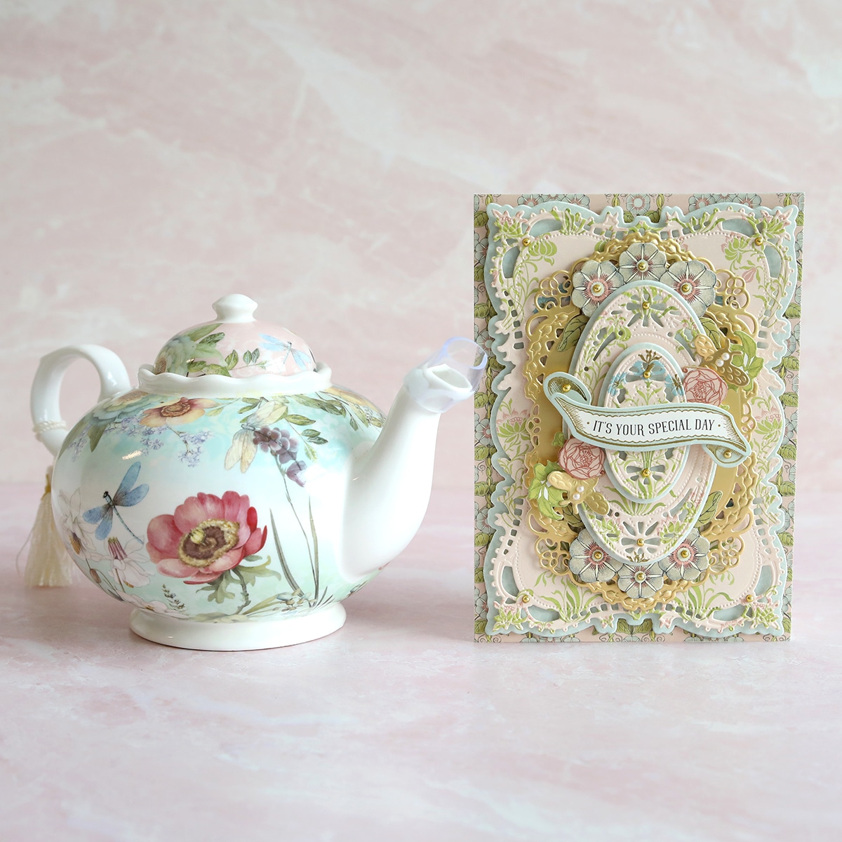 A teapot and a card next to each other.