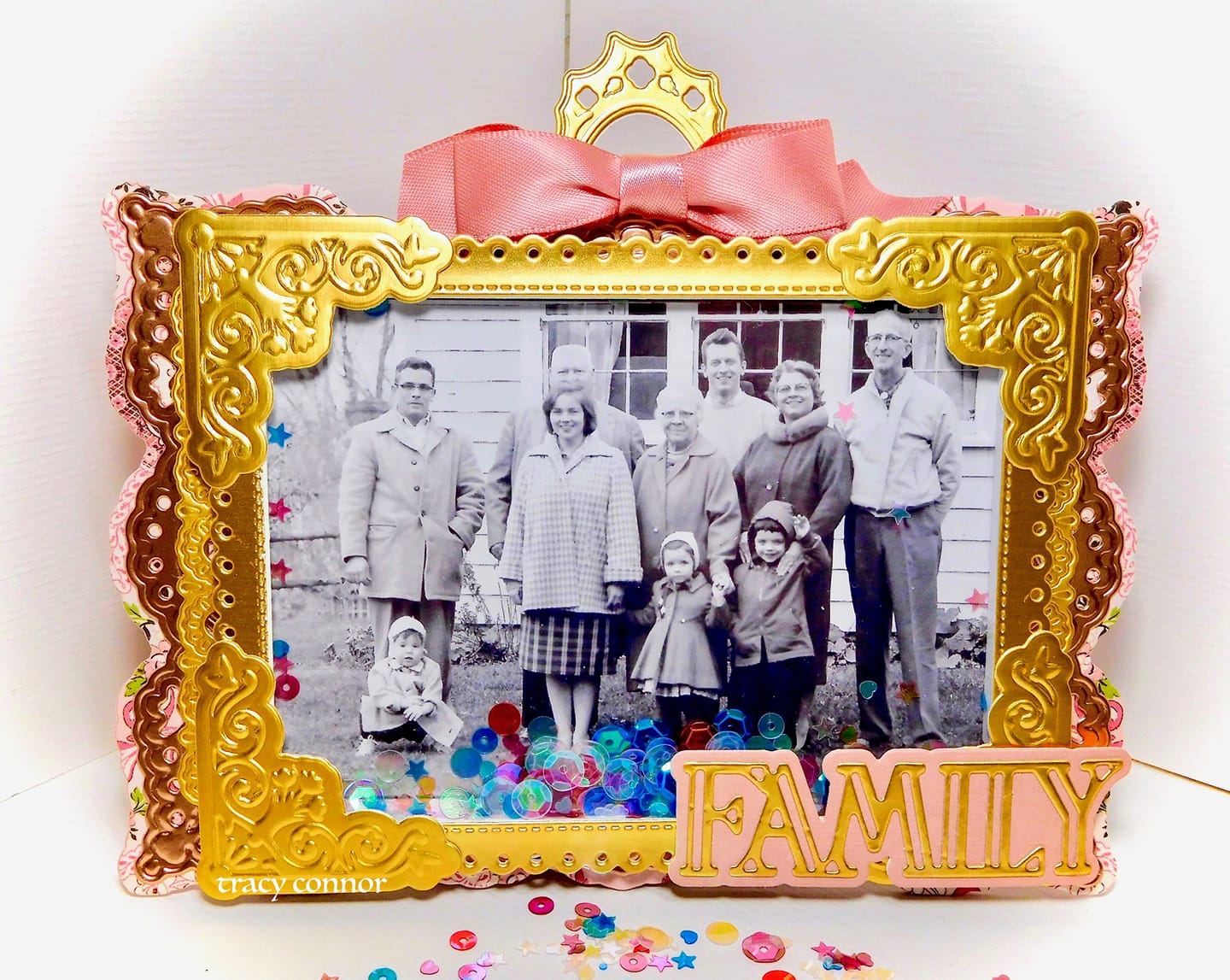 a family photo in a gold frame adorned with confetti.