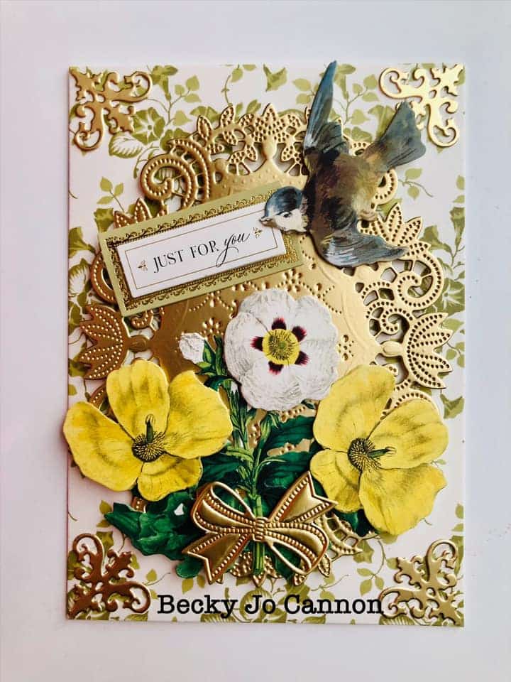 A gold and yellow card with a bird and flowers.