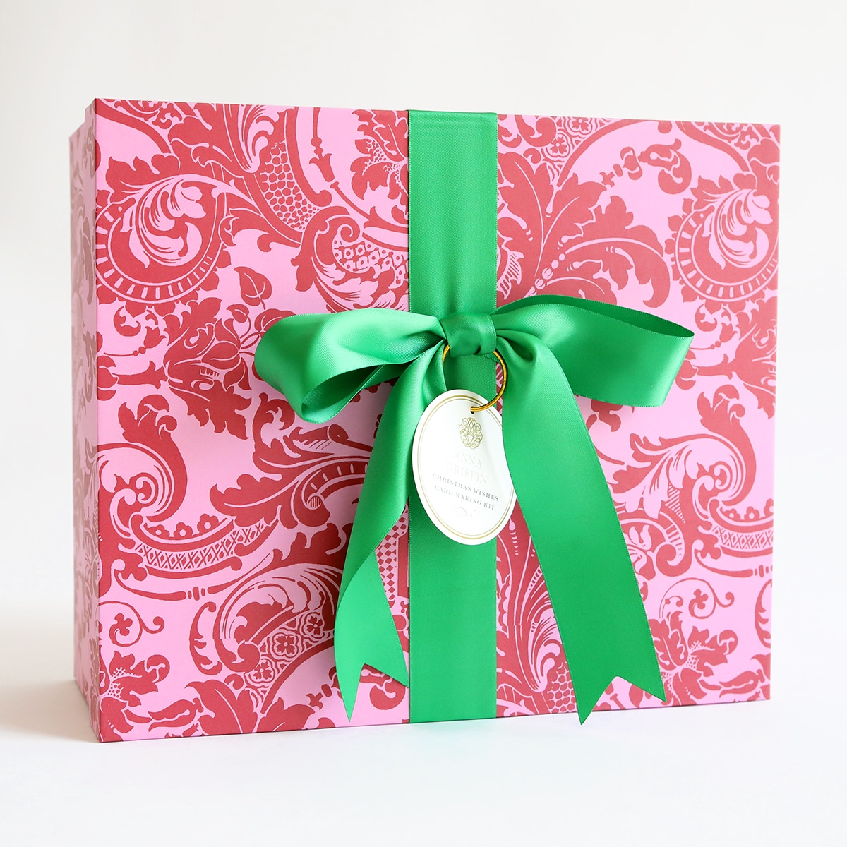 a pink and green gift box with a green ribbon.