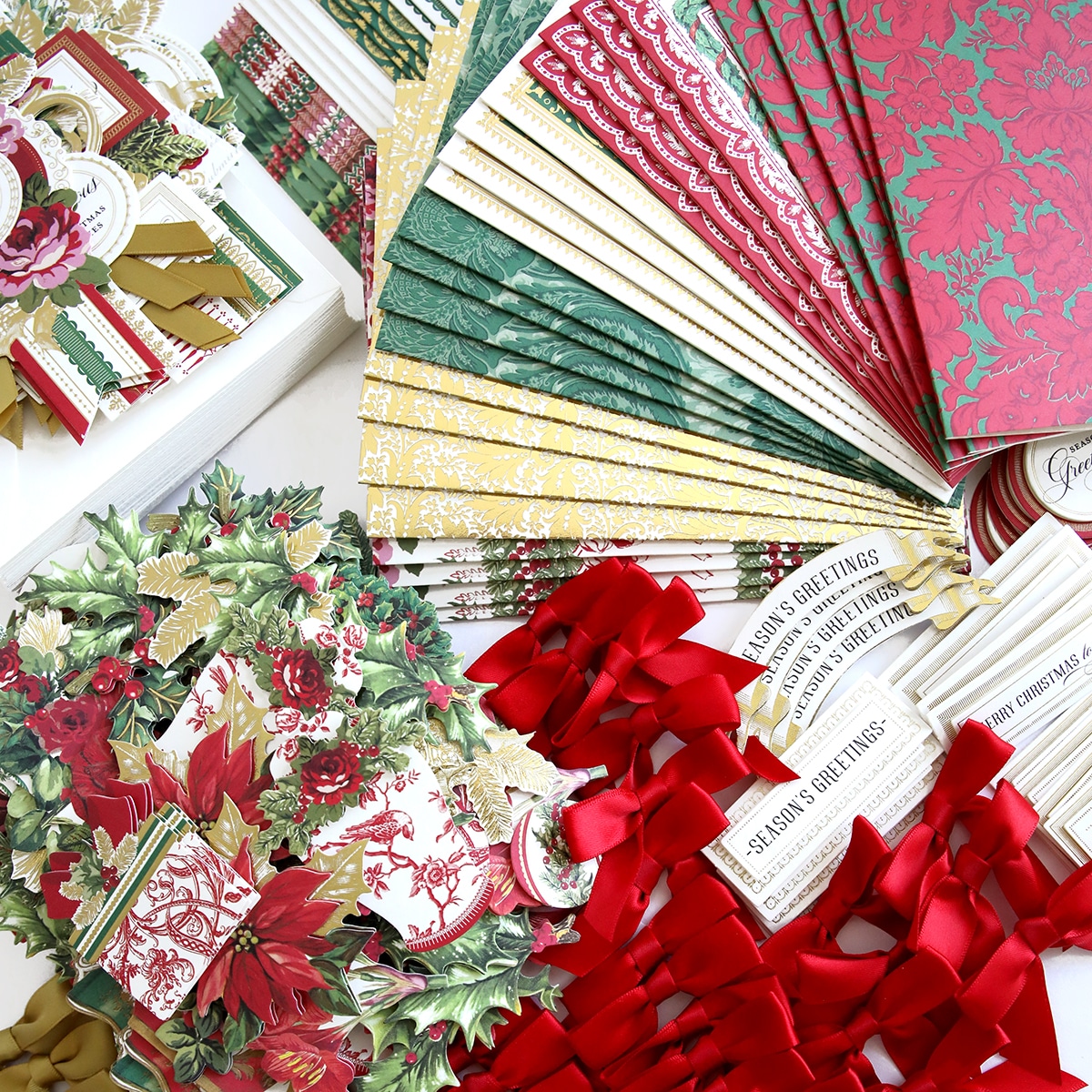 a collection of christmas papers and ribbons on a table.