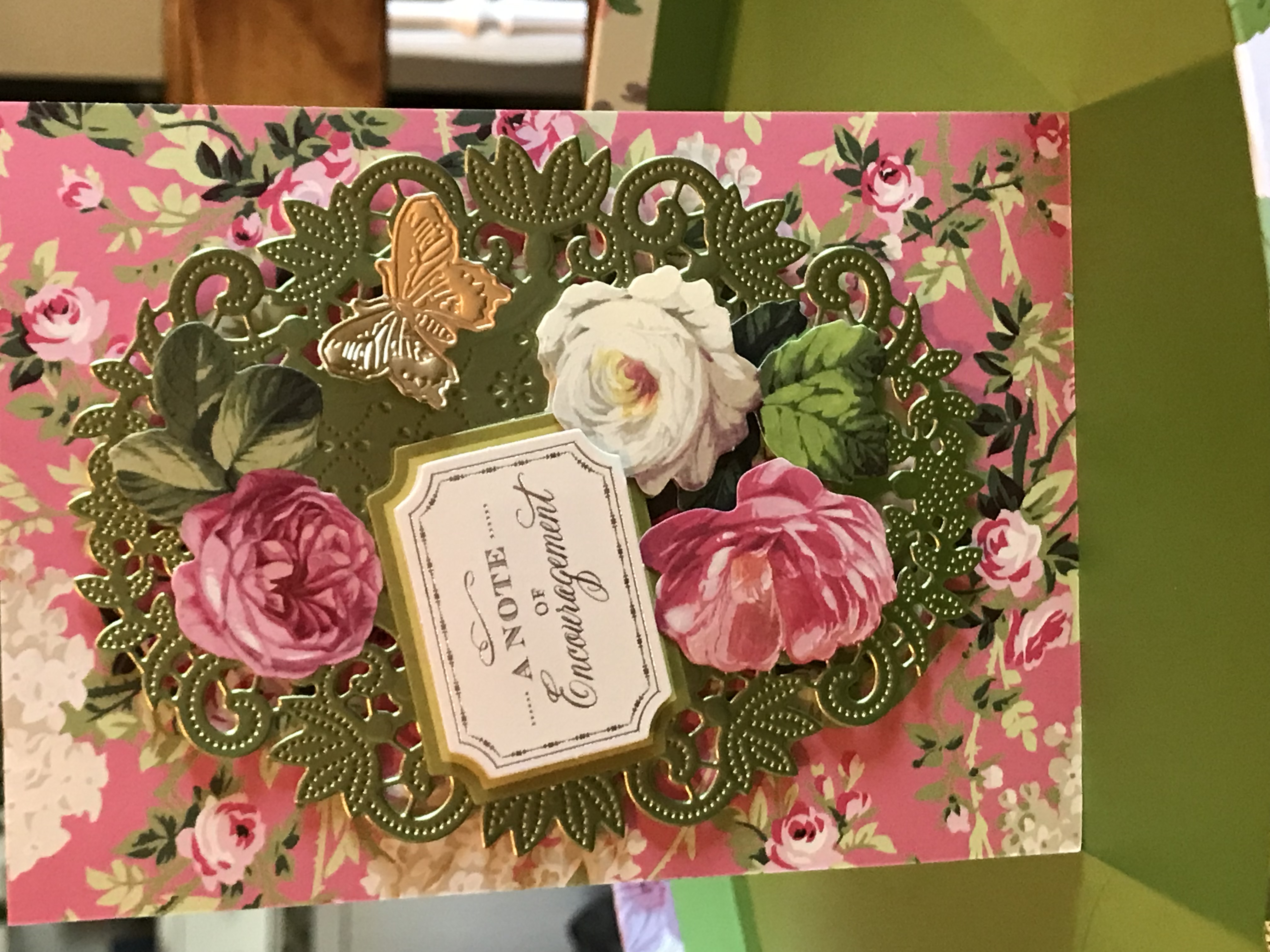 a pink and green card with roses on it.