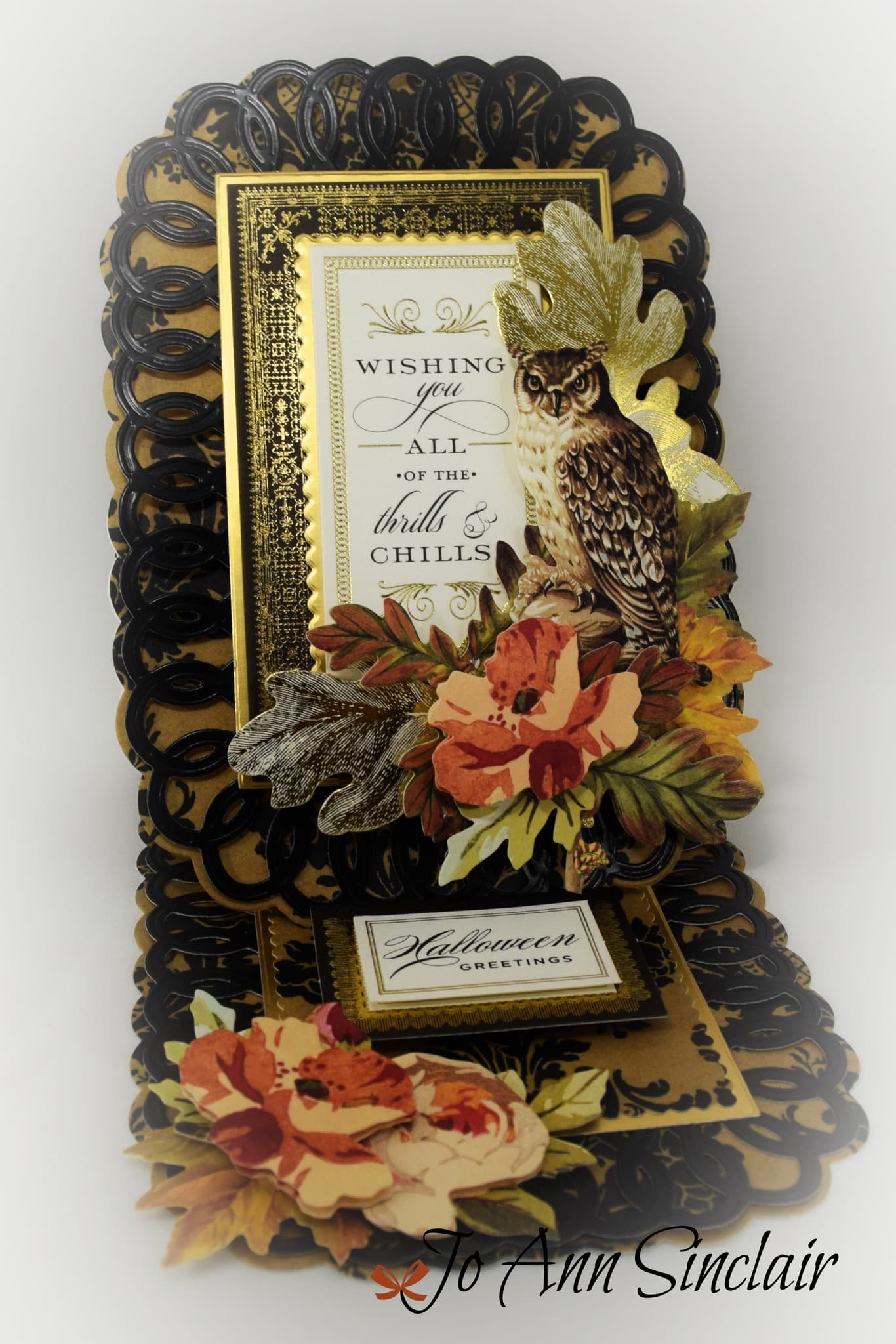 A black and gold card with an owl and flowers.
