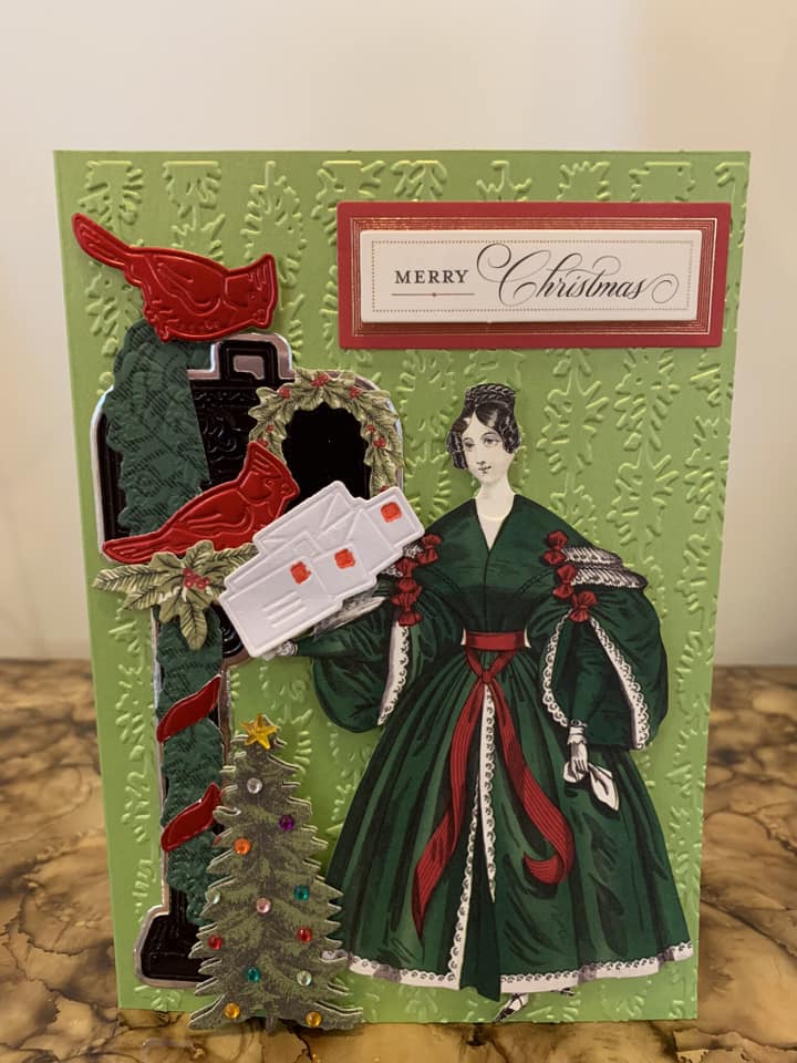 A christmas card with a woman in a green dress.