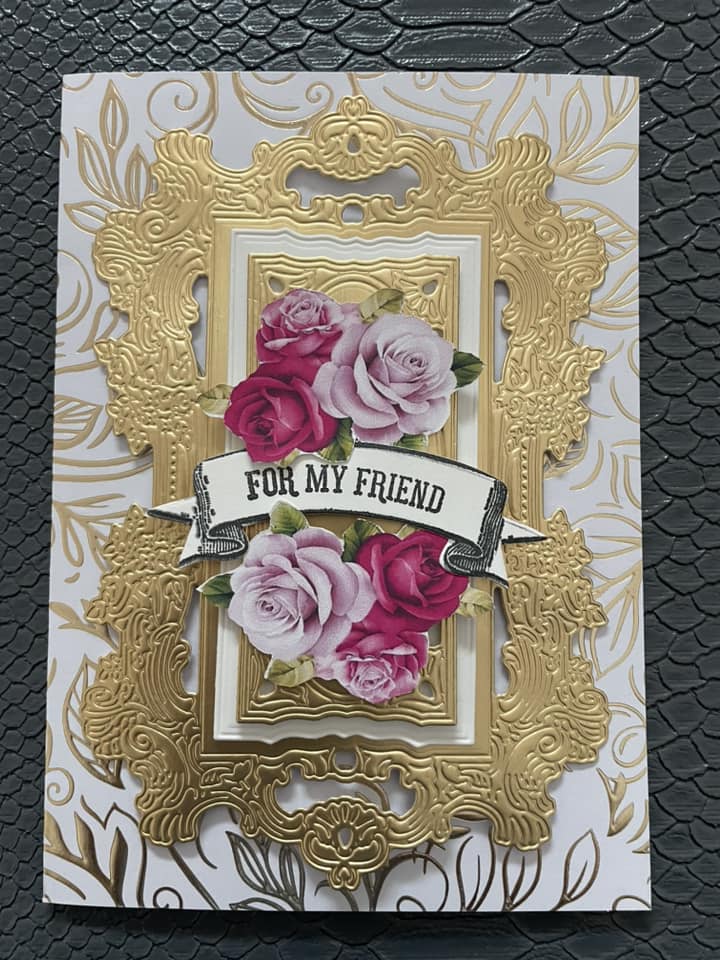 A gold and pink card with roses on it.