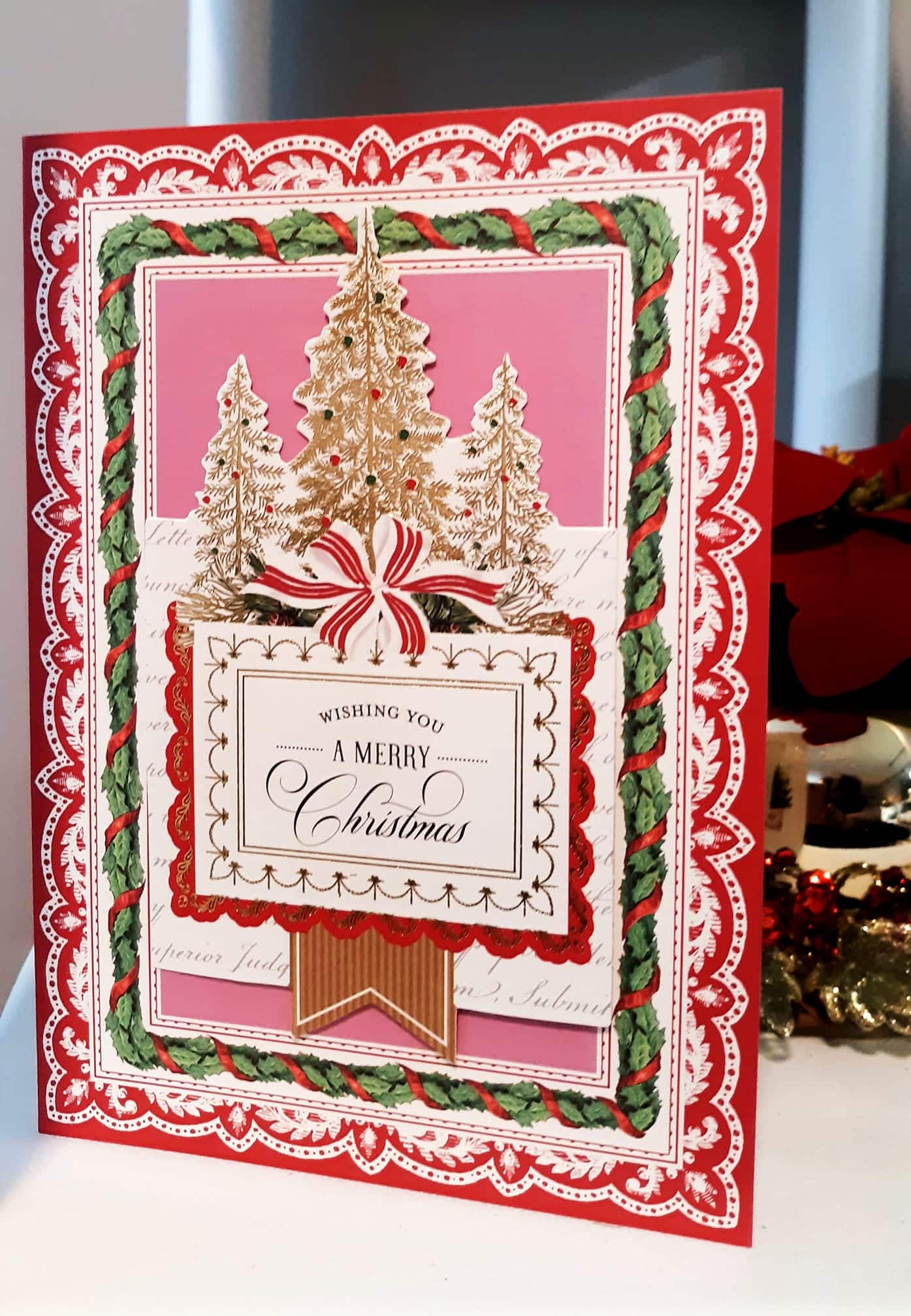 A christmas card with a gold and red border.