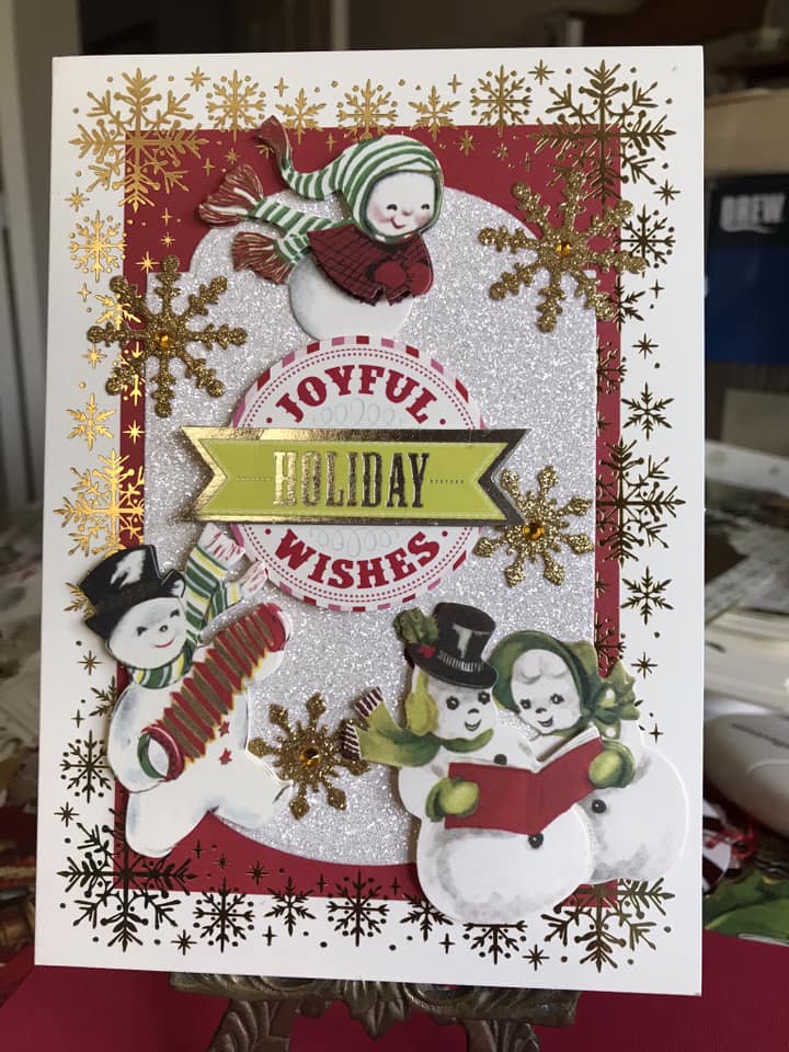 A christmas card with snowmen and snowflakes.