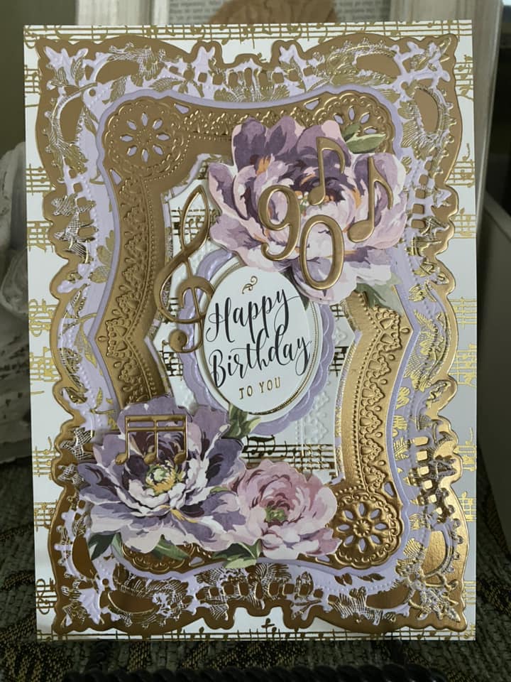 A purple and gold birthday card with flowers on it.
