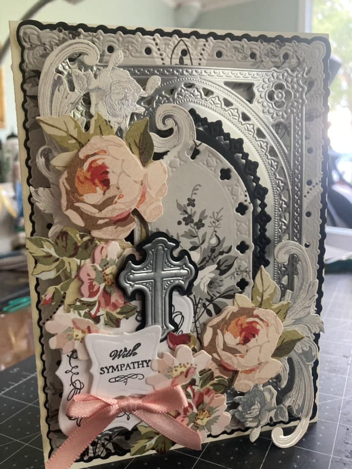 A card with a cross and roses on it.