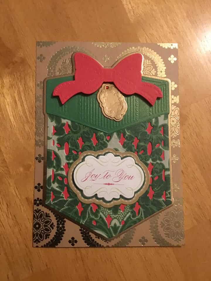 A christmas card with holly leaves and a bow.