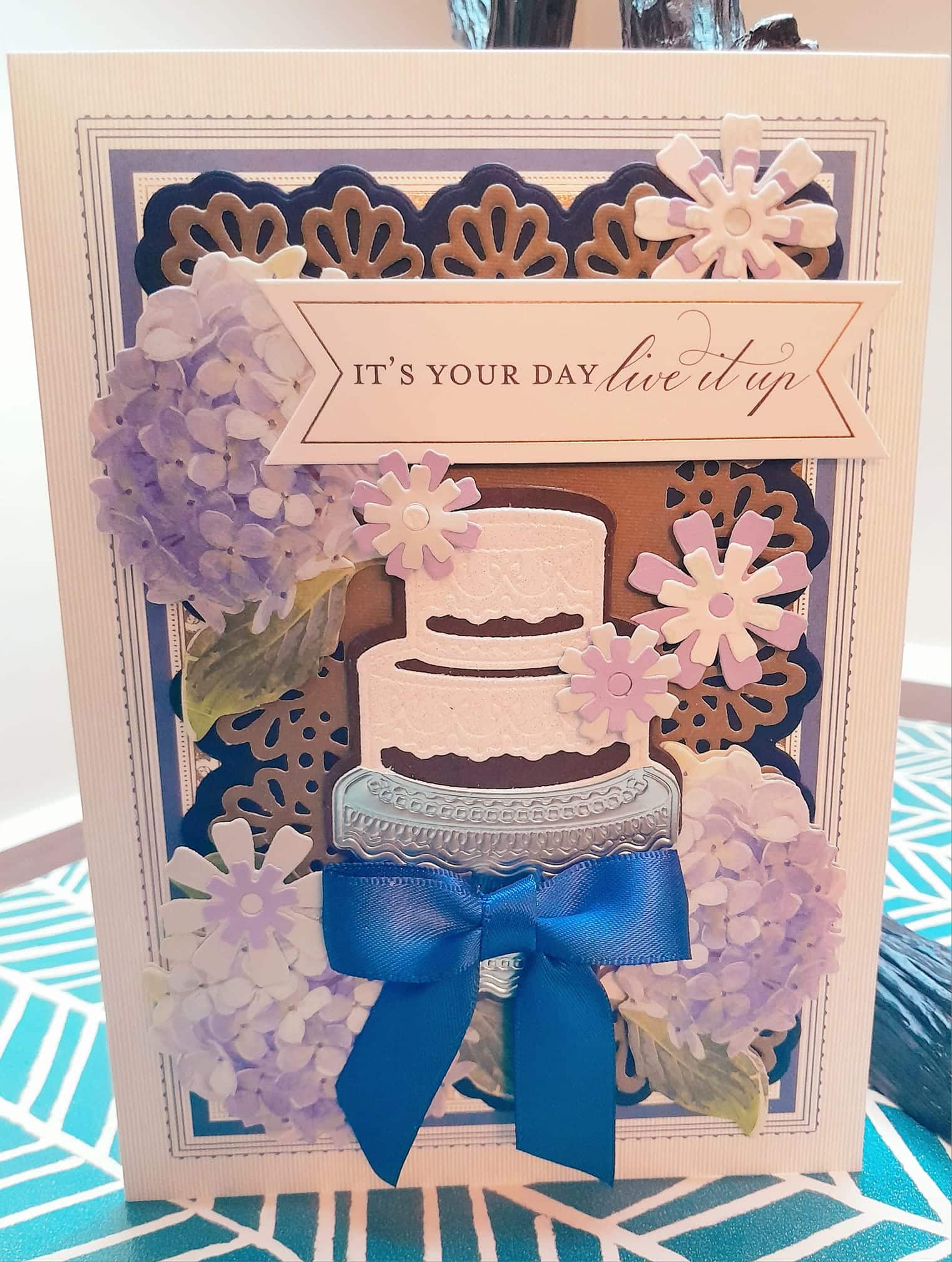 A card with a blue ribbon and a cake.