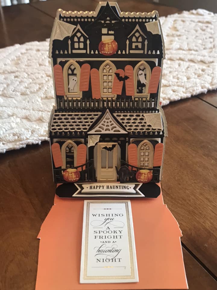 A tin box with a halloween house on it.