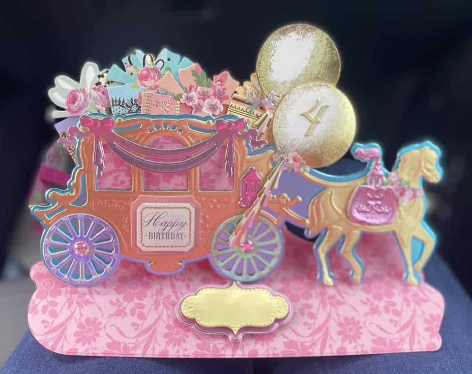 A pop up card with a carriage and balloons.