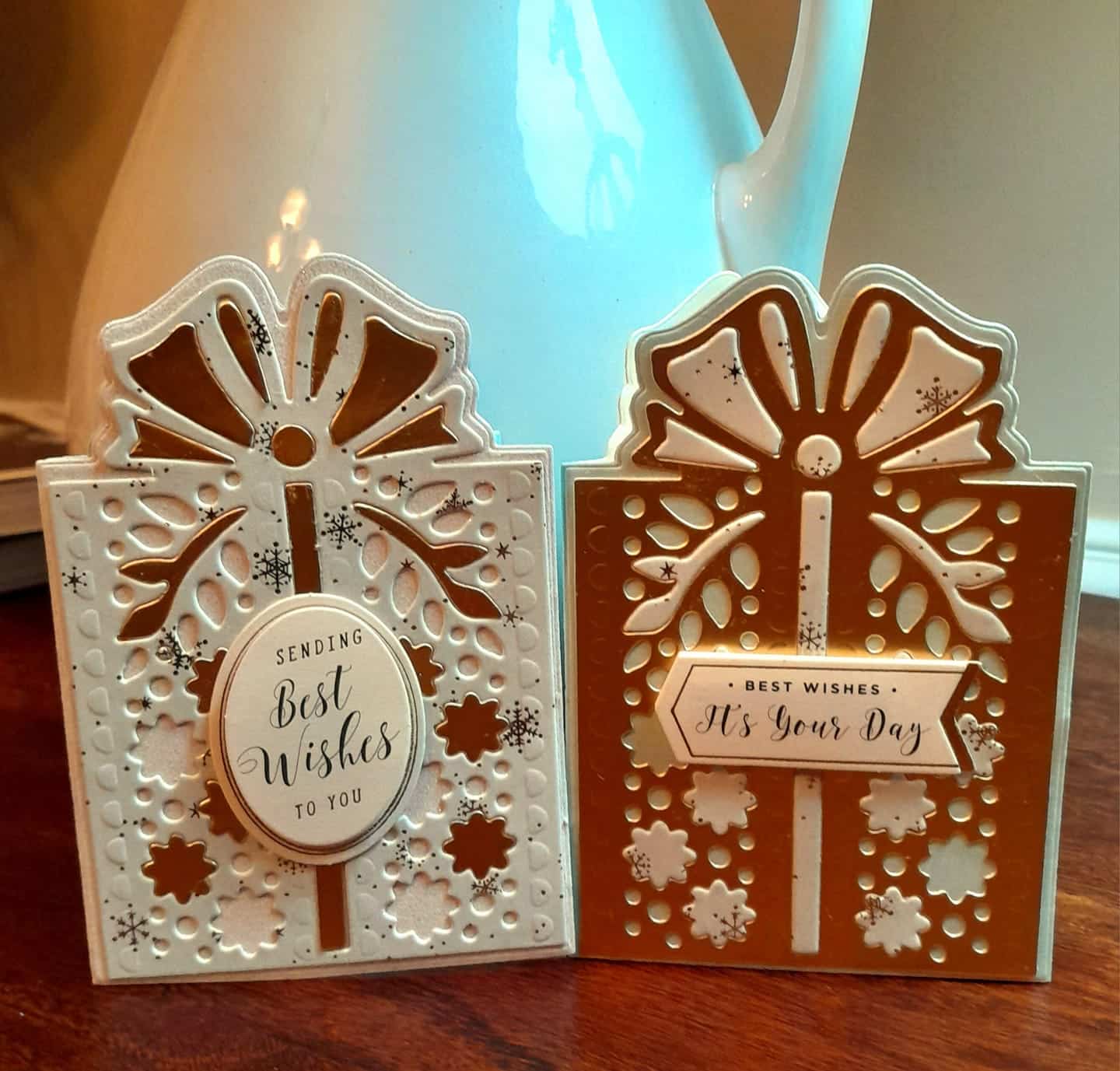 Two christmas cards with bows on them.