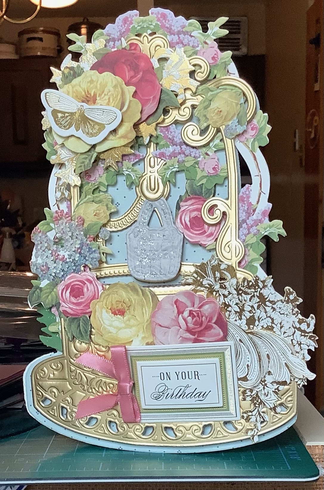 A card with a gold frame and flowers on it.