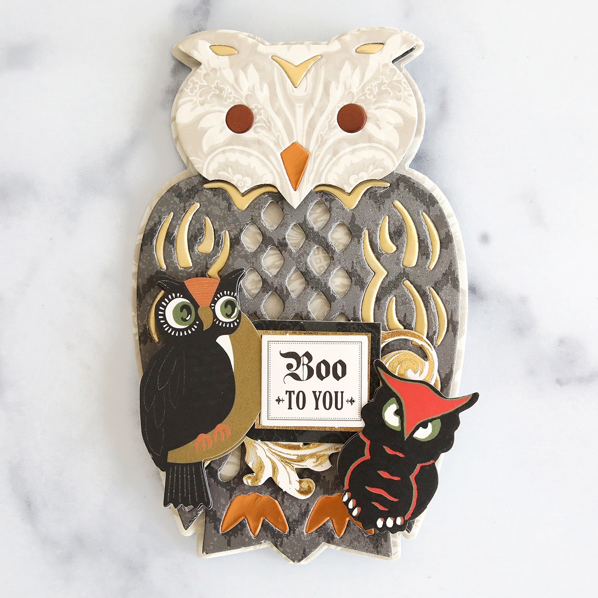 An owl and two owls on a marble surface.