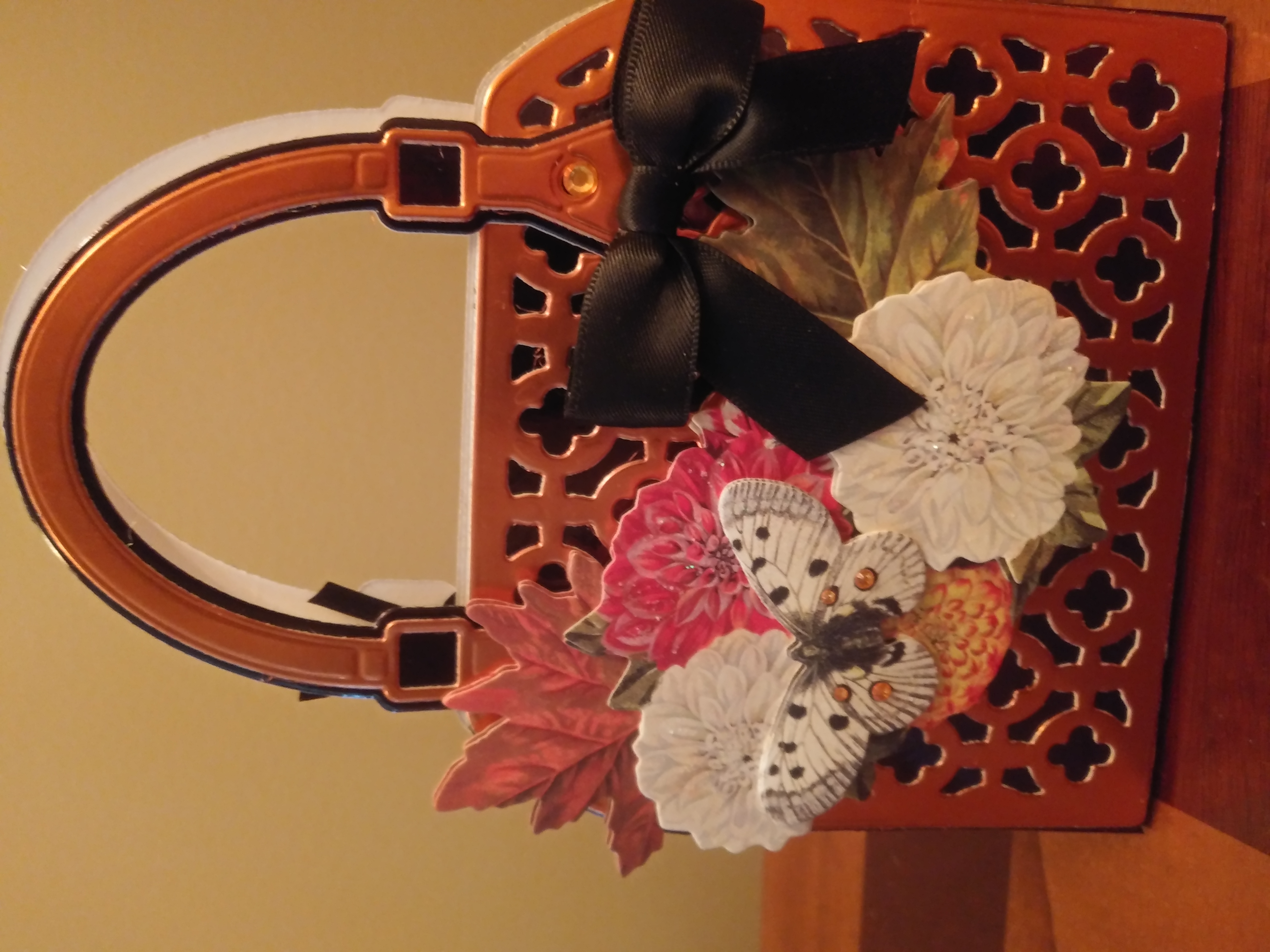 A handbag decorated with flowers and butterflies.