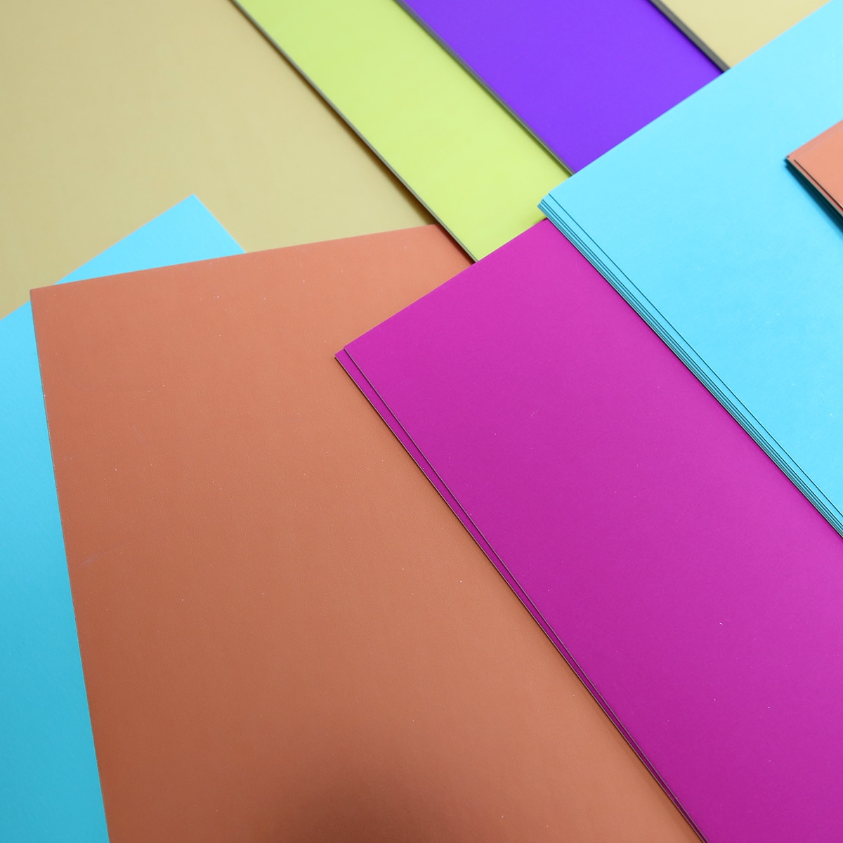 A pile of colored paper on a flat surface.