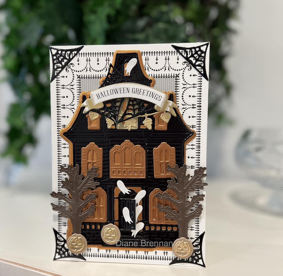 A halloween card with a house and bats on it.