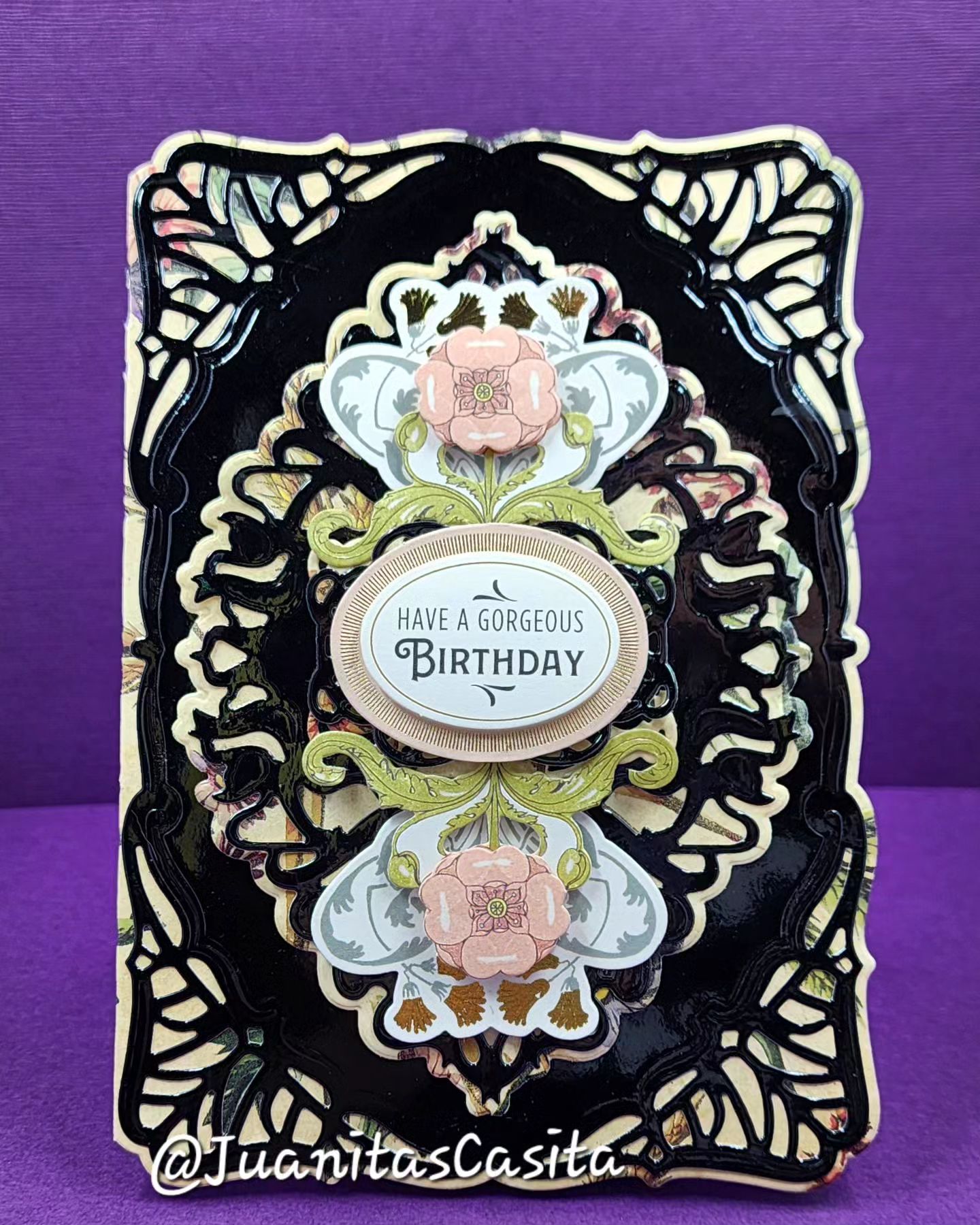 A black and gold birthday card with flowers on it.
