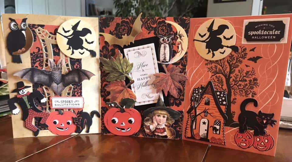 Three halloween cards with witches and bats on them.