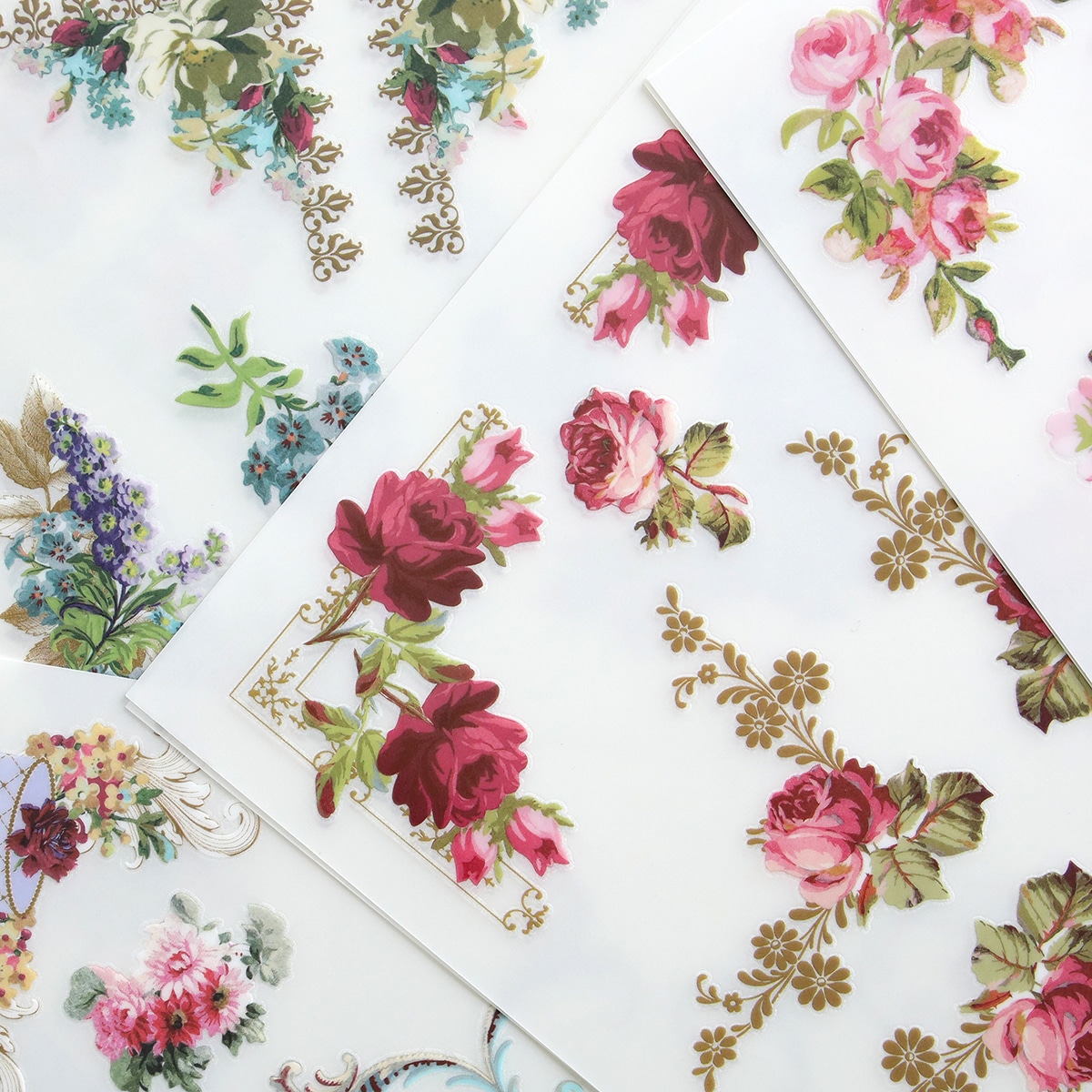 A variety of roses and floral designs are placed on a sheet of paper.