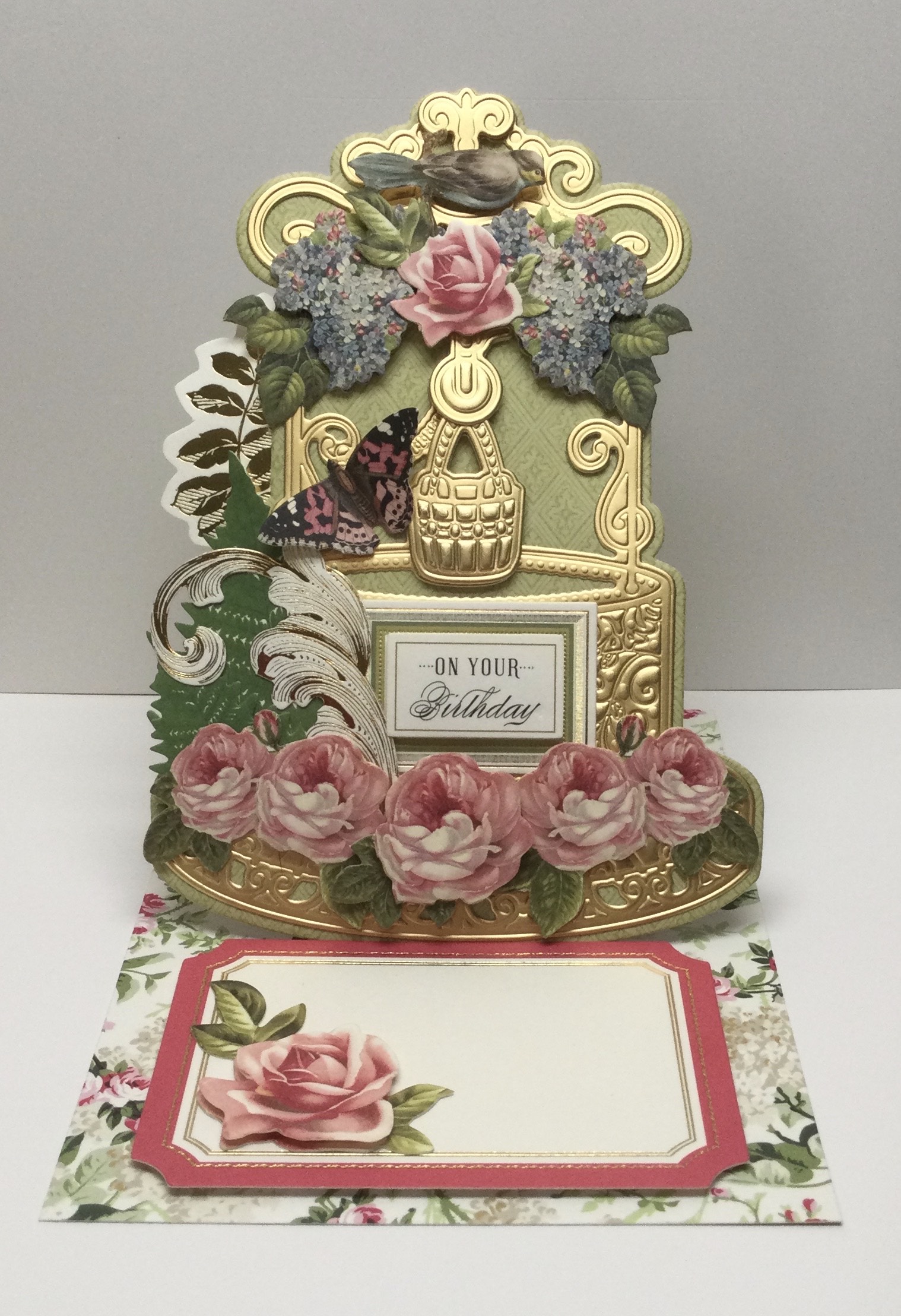 A pop up card with flowers and a clock.