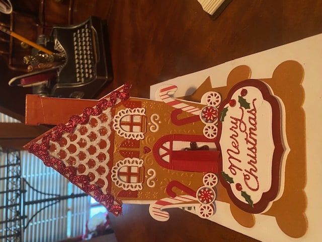 A christmas card with a gingerbread house on it.