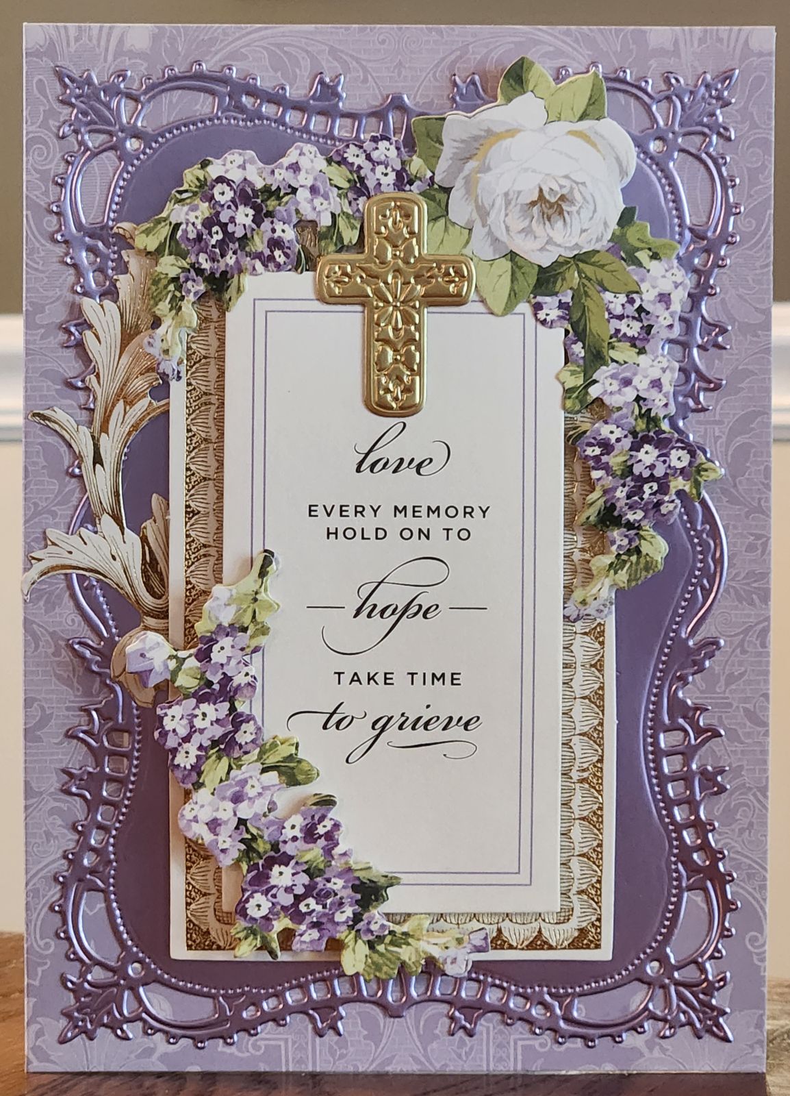 A purple card with a cross and flowers.