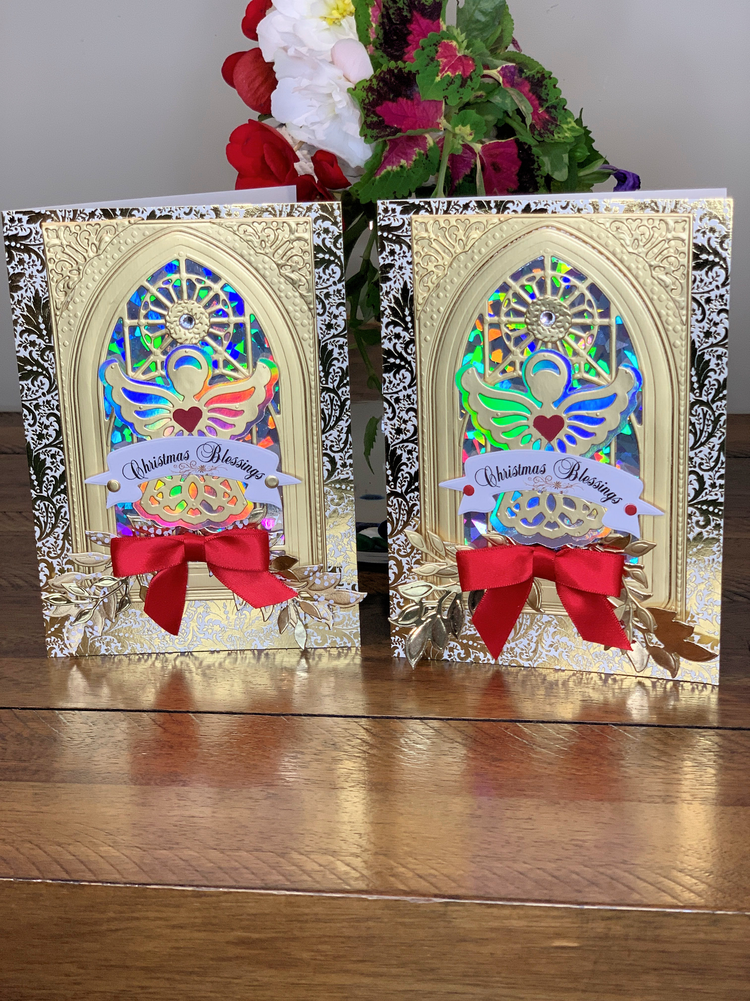 Two christmas cards with red bows on them.