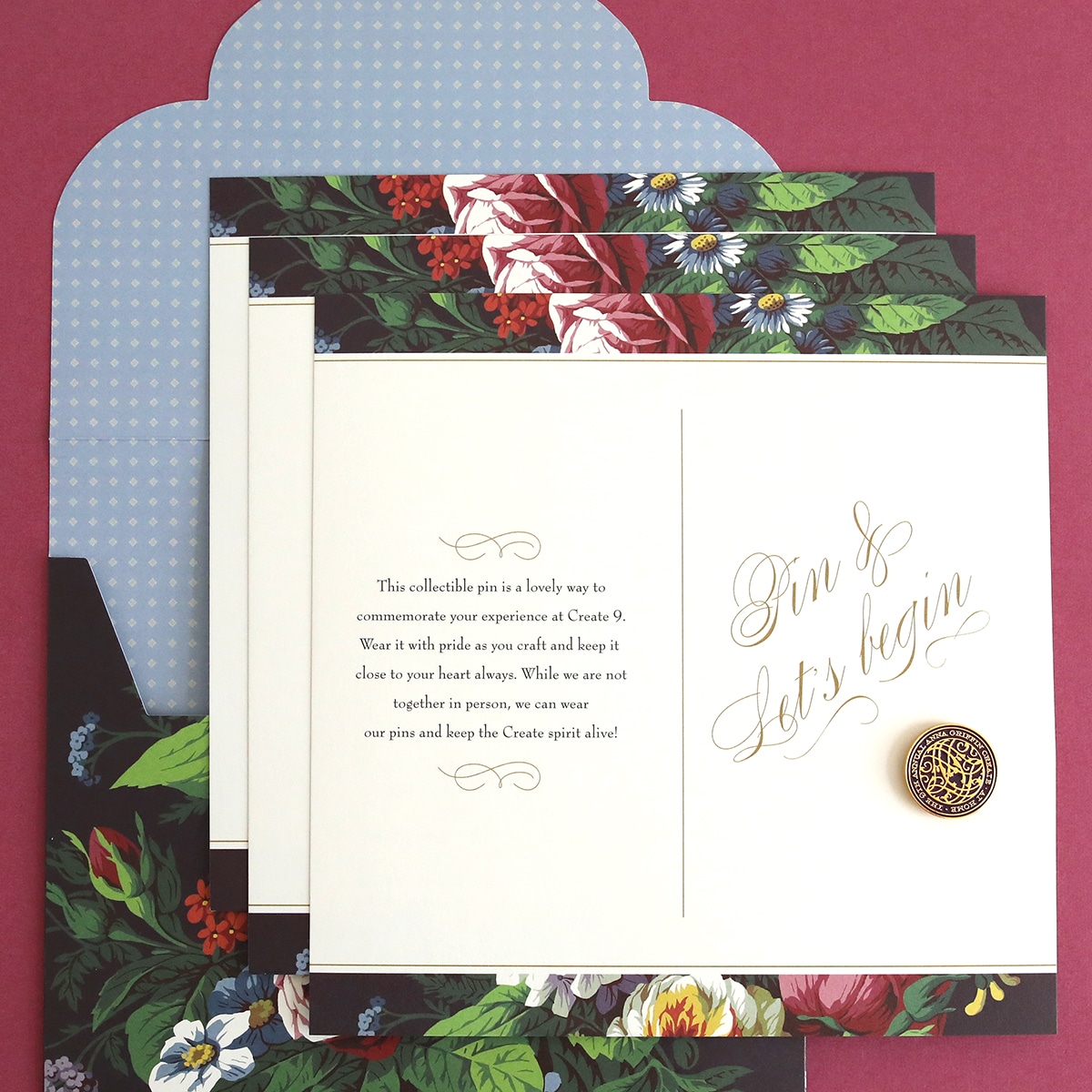 A set of floral wedding invitations with a button.