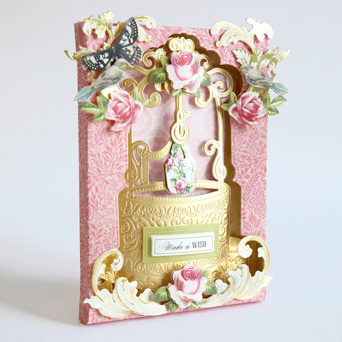 A pink card with roses and butterflies on it.