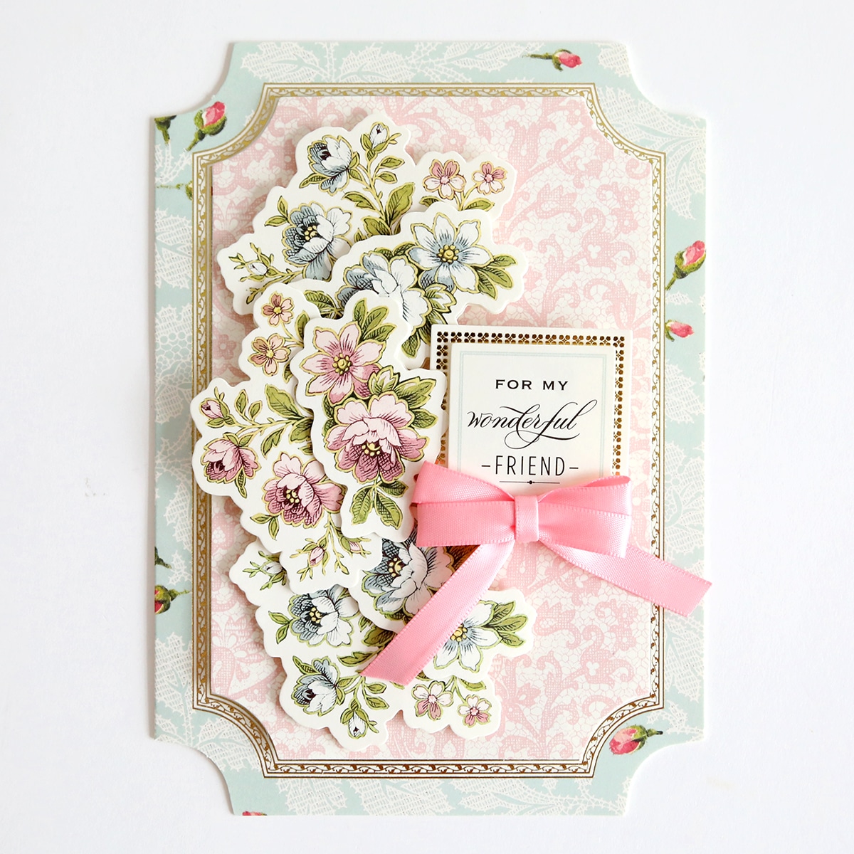 A card with a pink ribbon and flowers.
