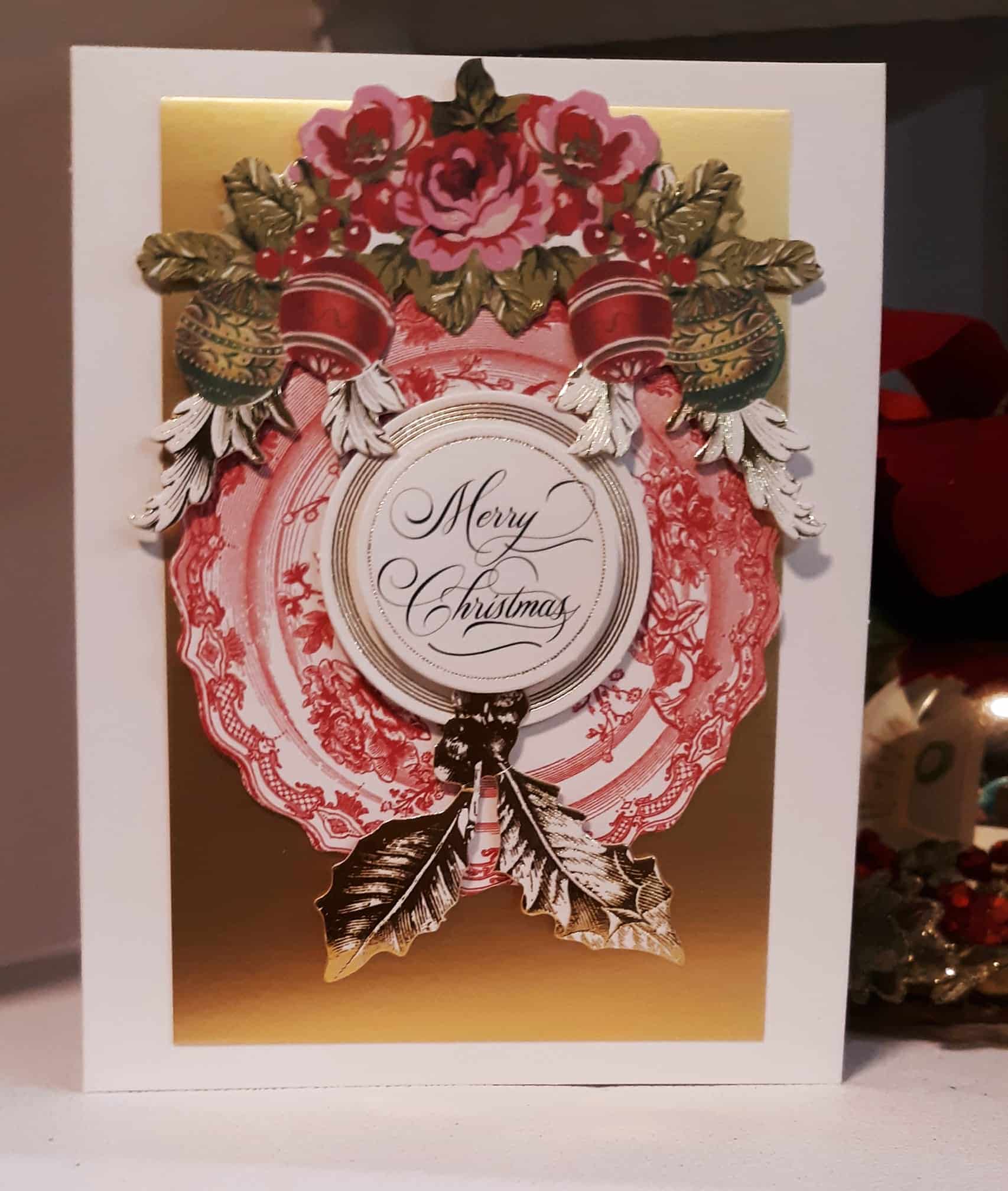 A merry christmas card with red and gold decorations.