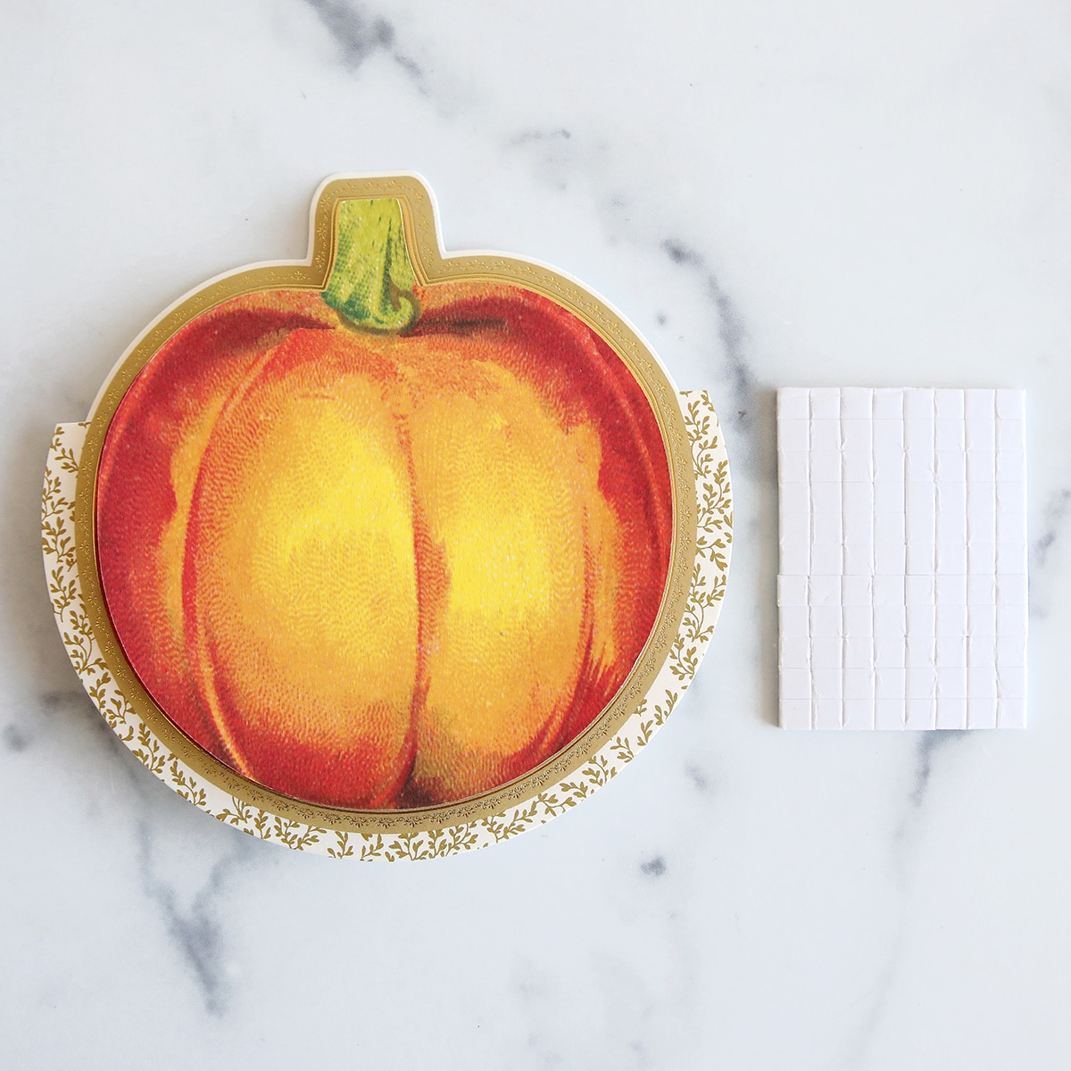 A notepad with a painted pumpkin on it.