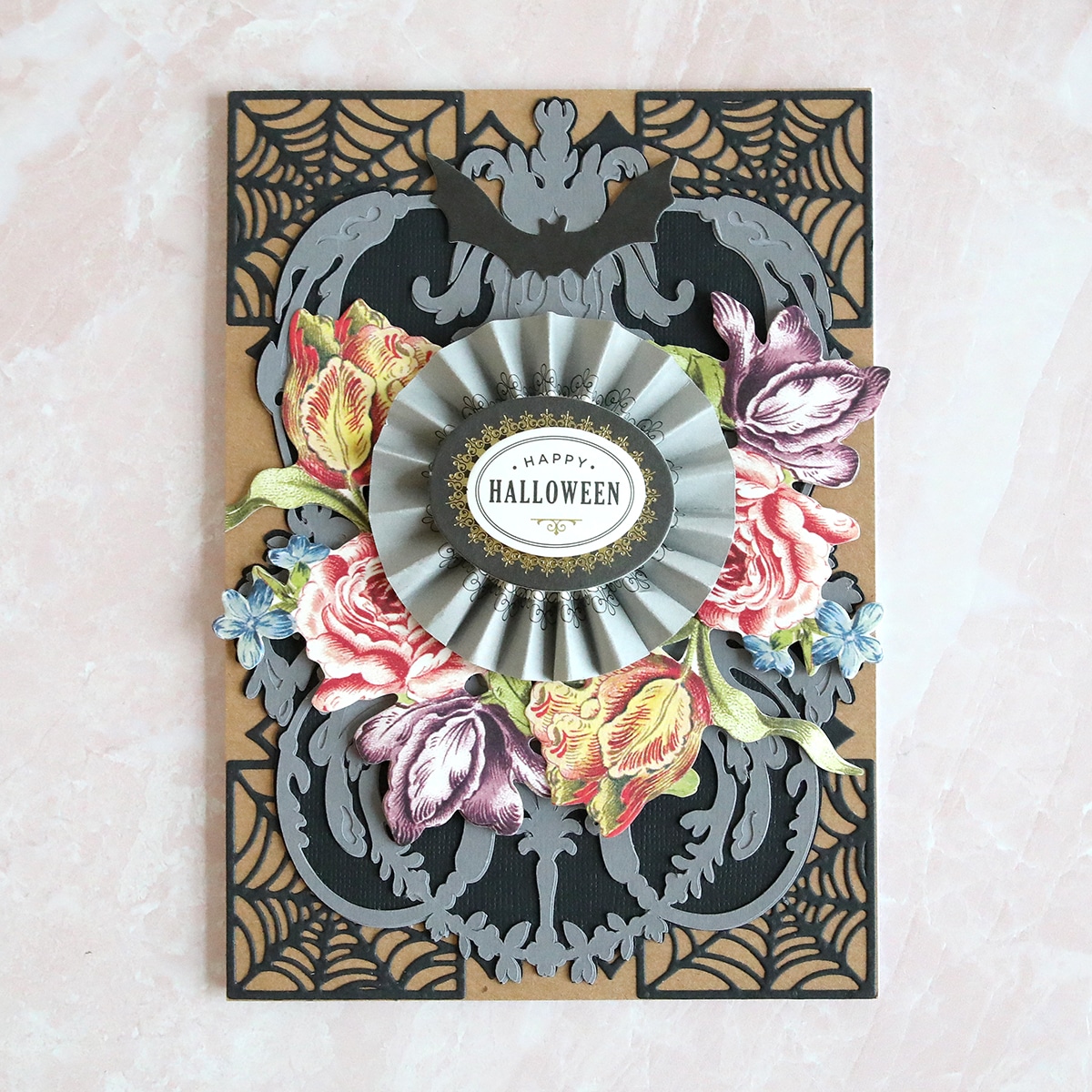 A halloween card with flowers and a ribbon.